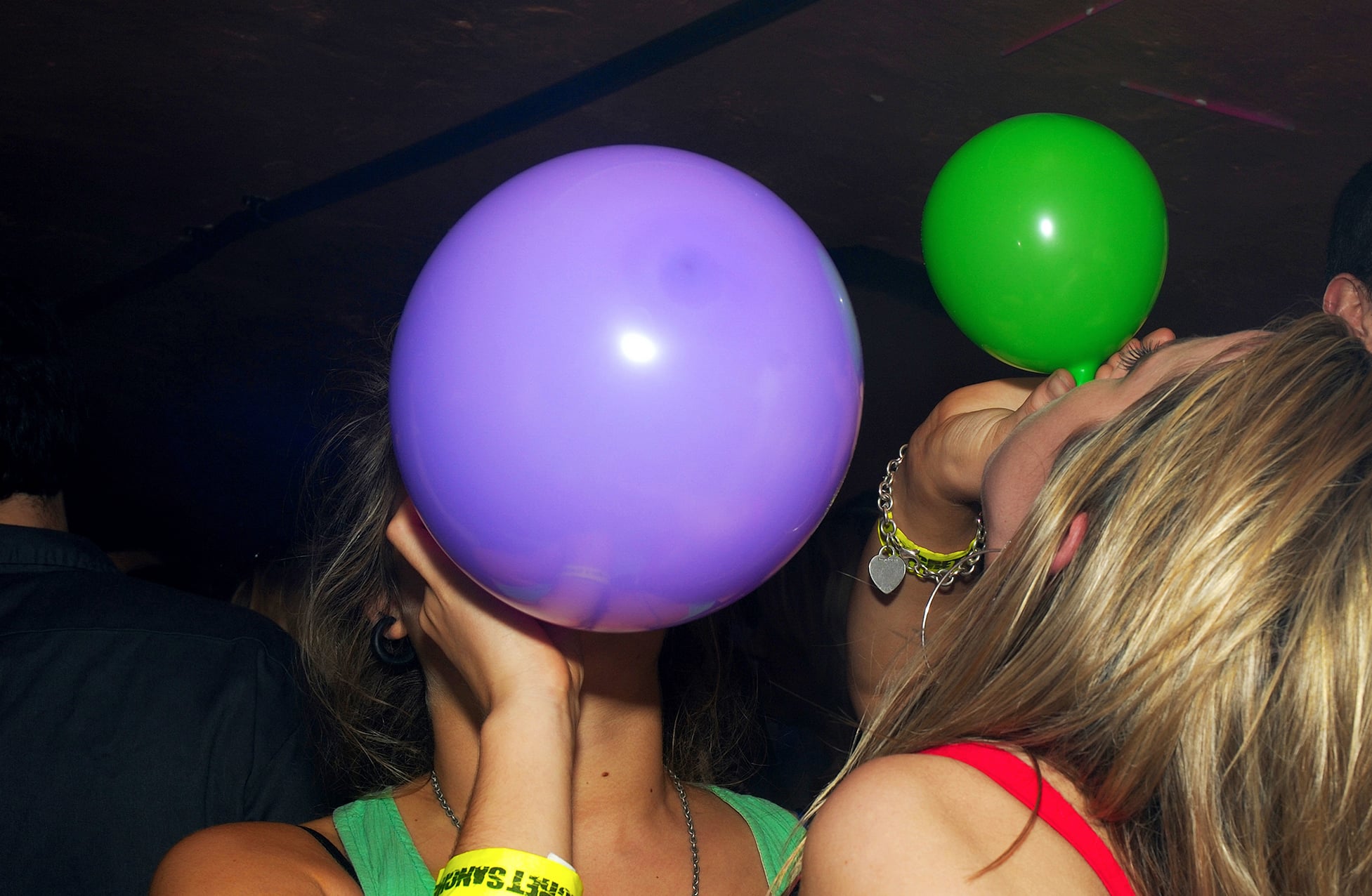 Partygoers inhaling nitrous oxide.