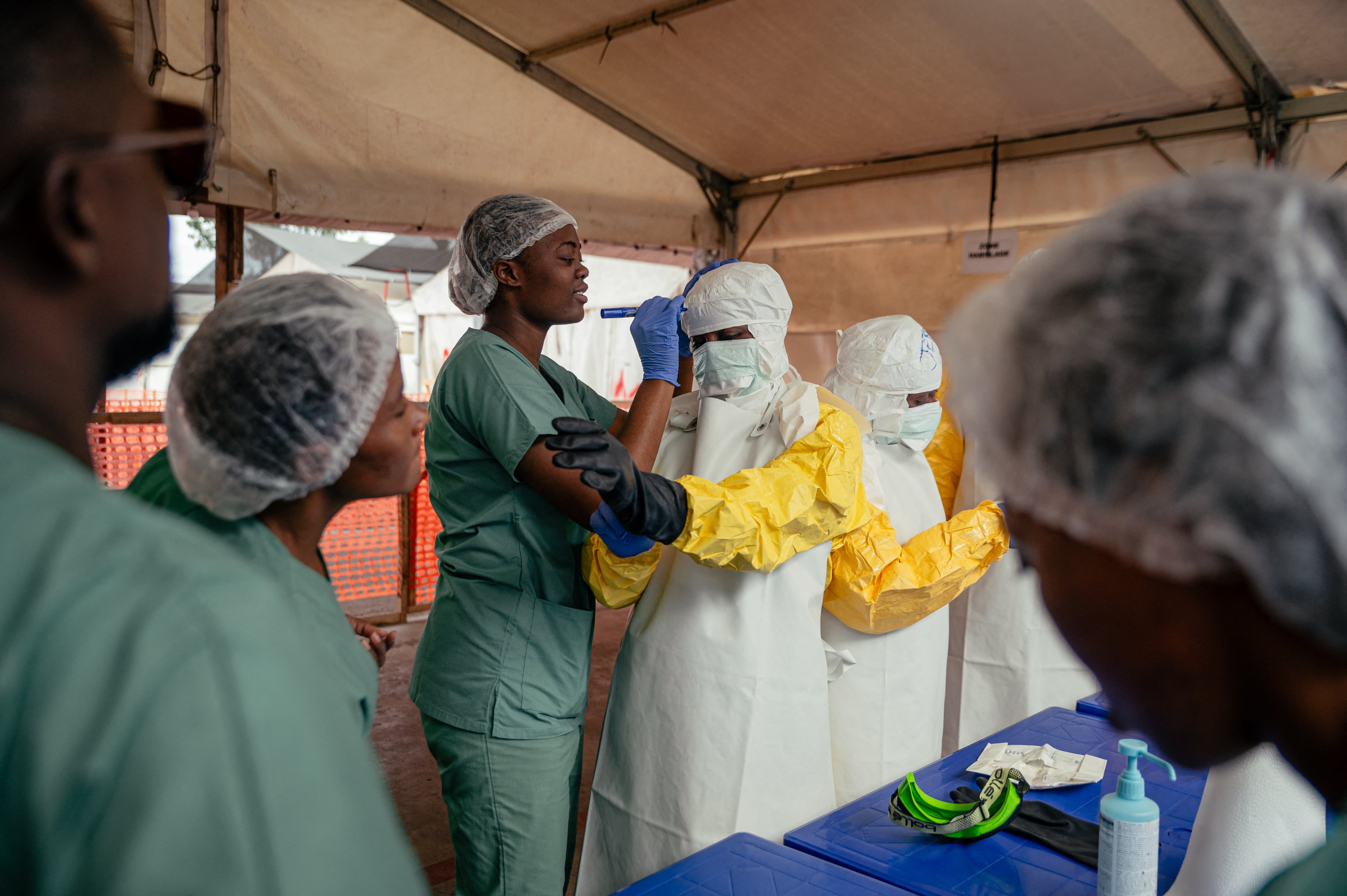 Healthcare workers don PPE at an ebola treatment centre in Munigi, DRC.