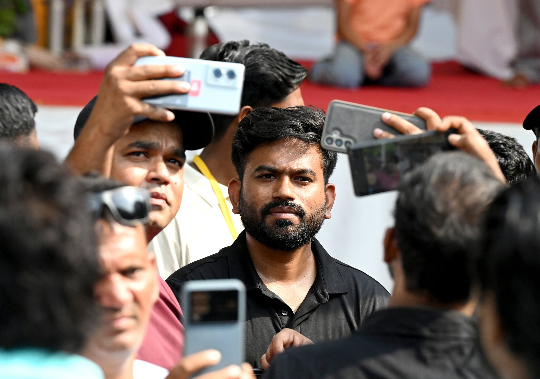 A crowd takes pictures with their smartphones of Cockroach Janta Party founder Abhijeet Dipke.