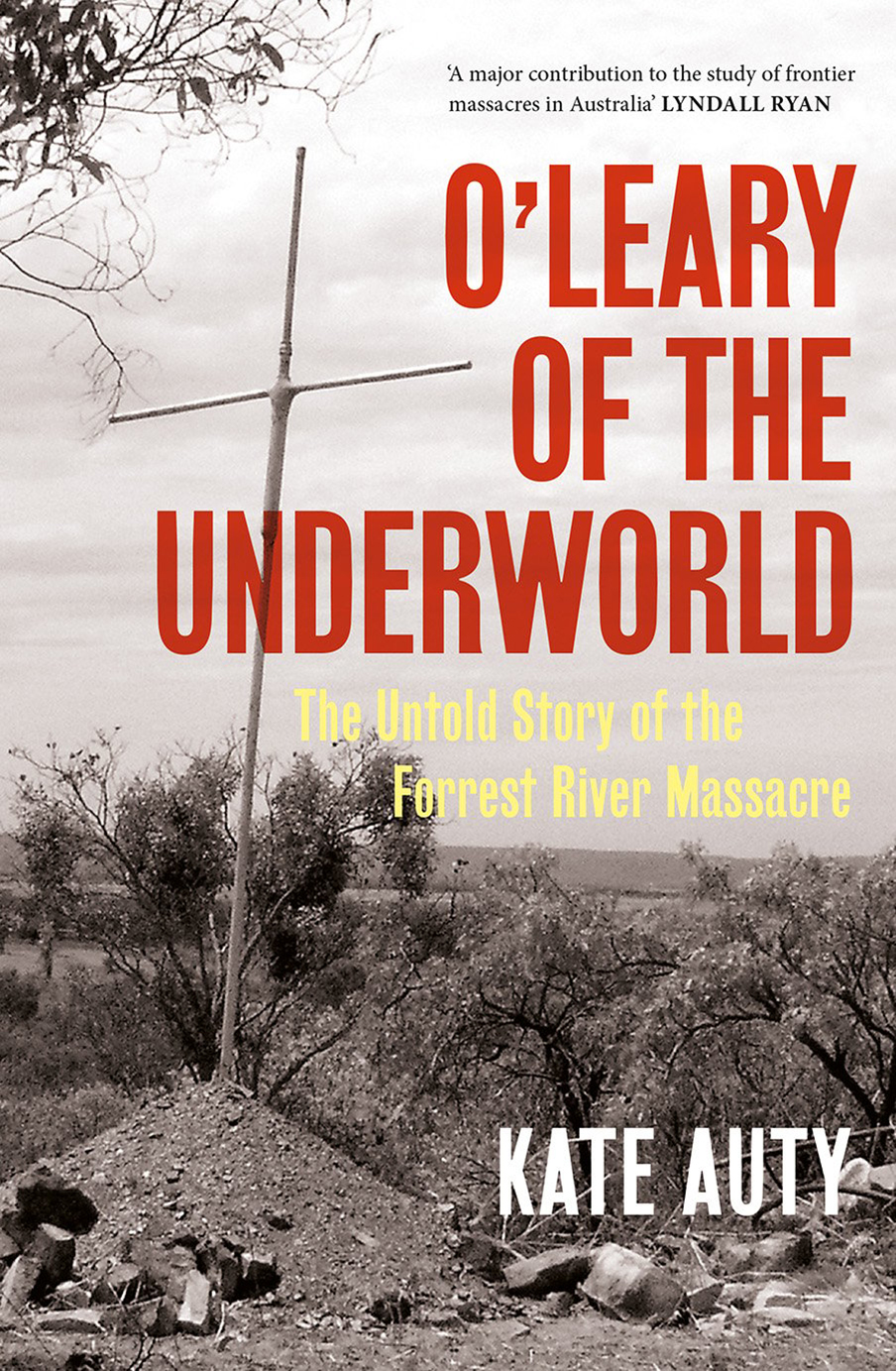 Book cover: the book title printed in red text and the author's name in what. In the foreground is a cross stuck in the ground with debris scattered around it. In the background there is dry bushland
