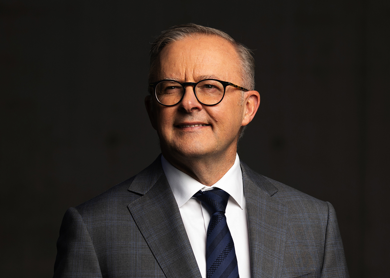 Anthony Albanese wearing glasses and a grey suit.