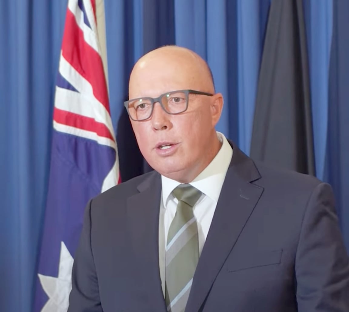 Peter Dutton at a press conference with an Australia flag behind him.
