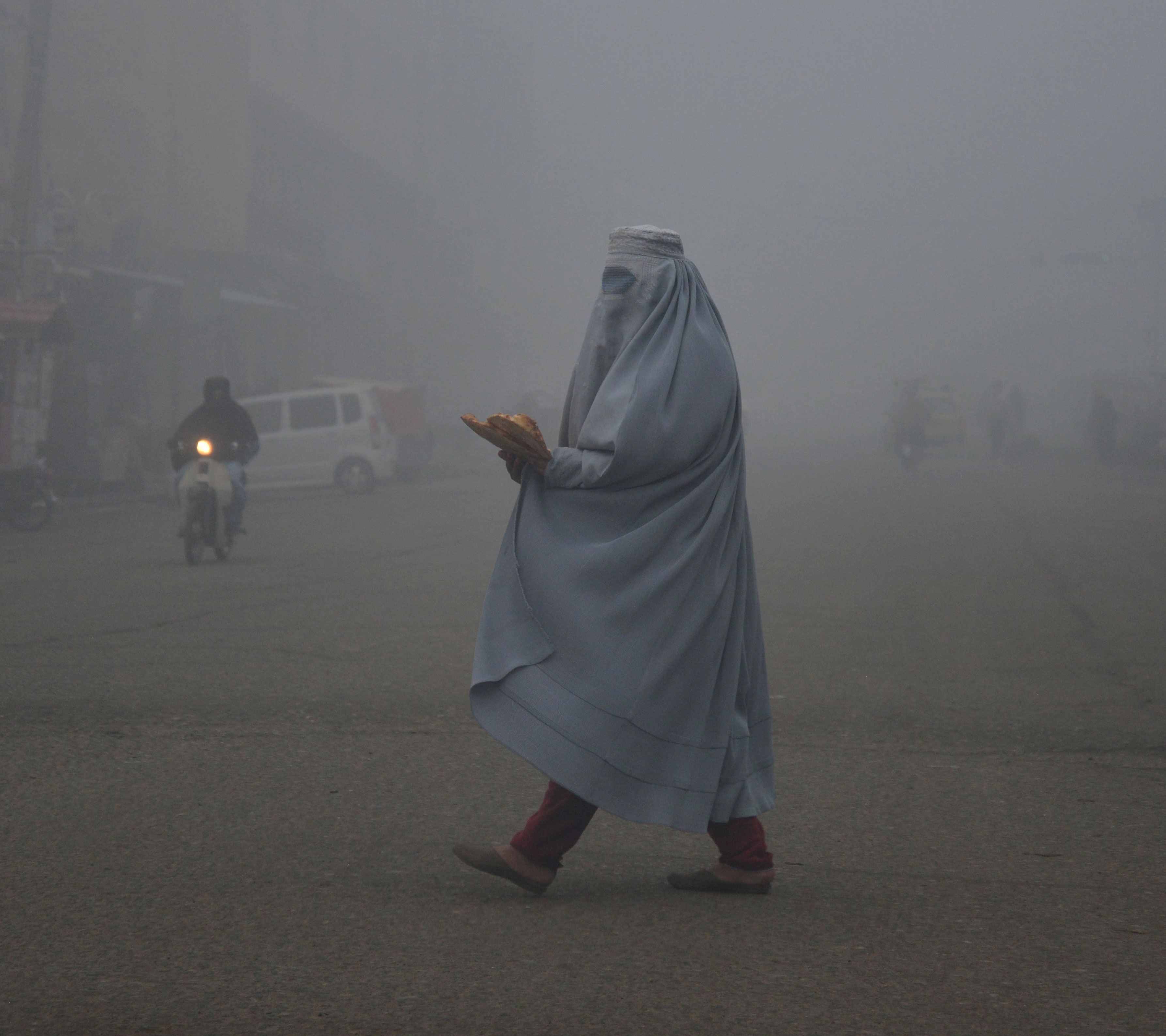 An Afghan woman wears a burqa on a road in Kandahar.