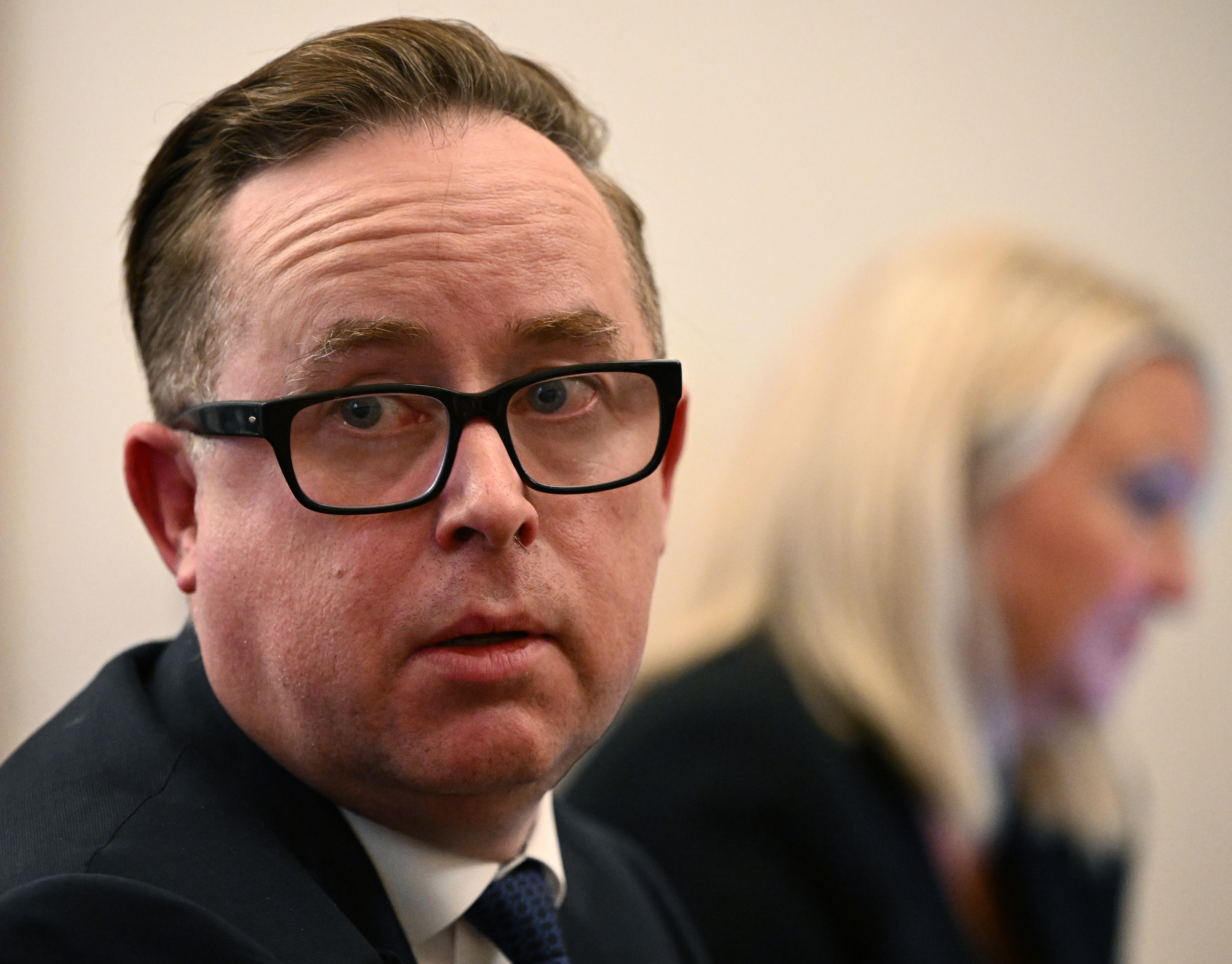 A man wearing glasses and a suit.