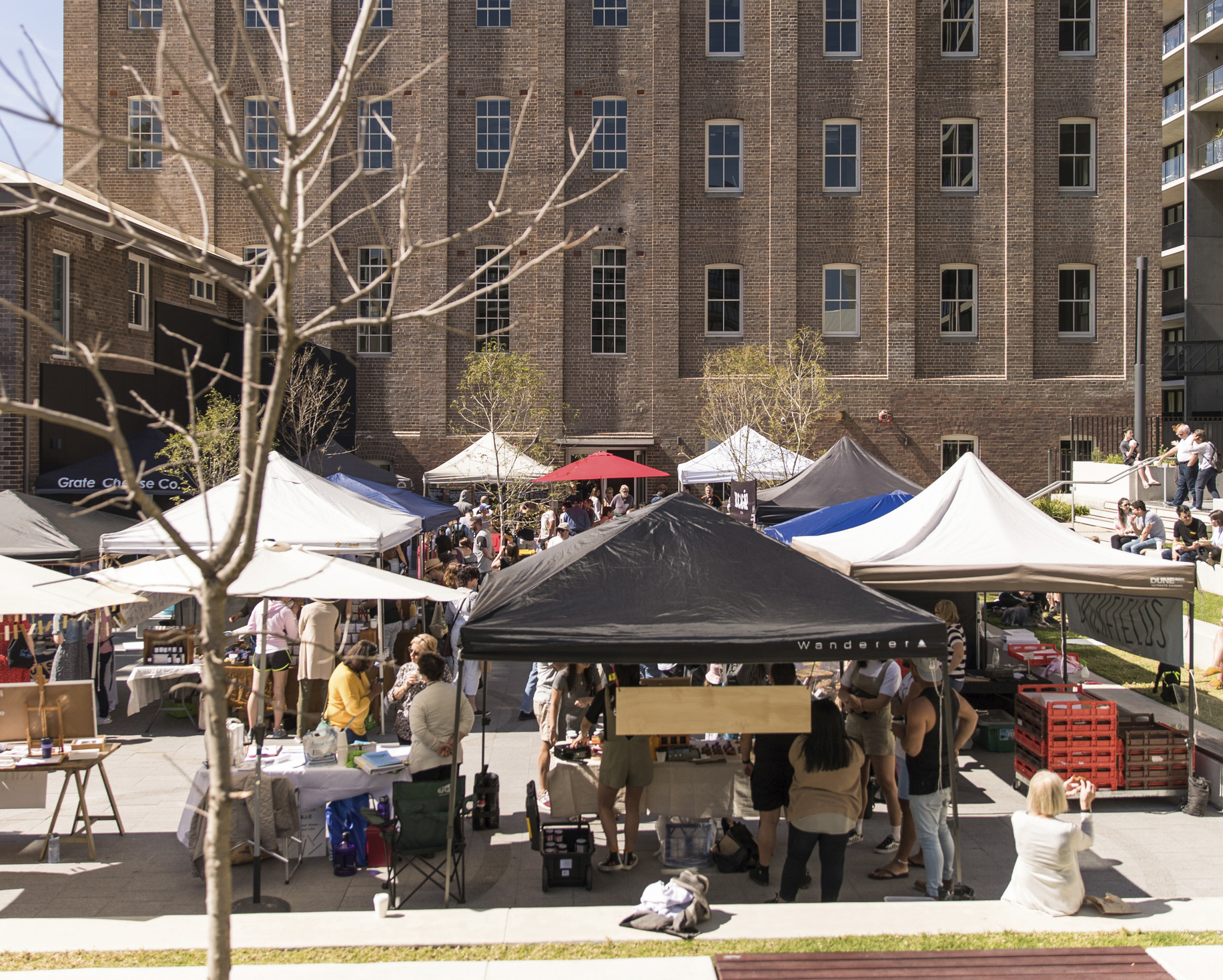 A market with a tall brick building in the background.