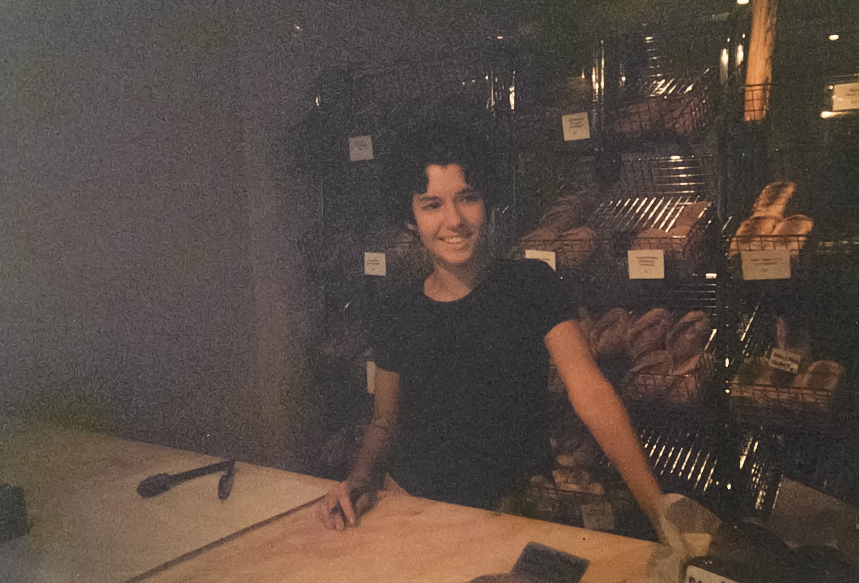 A young woman at the counter of a bakery.