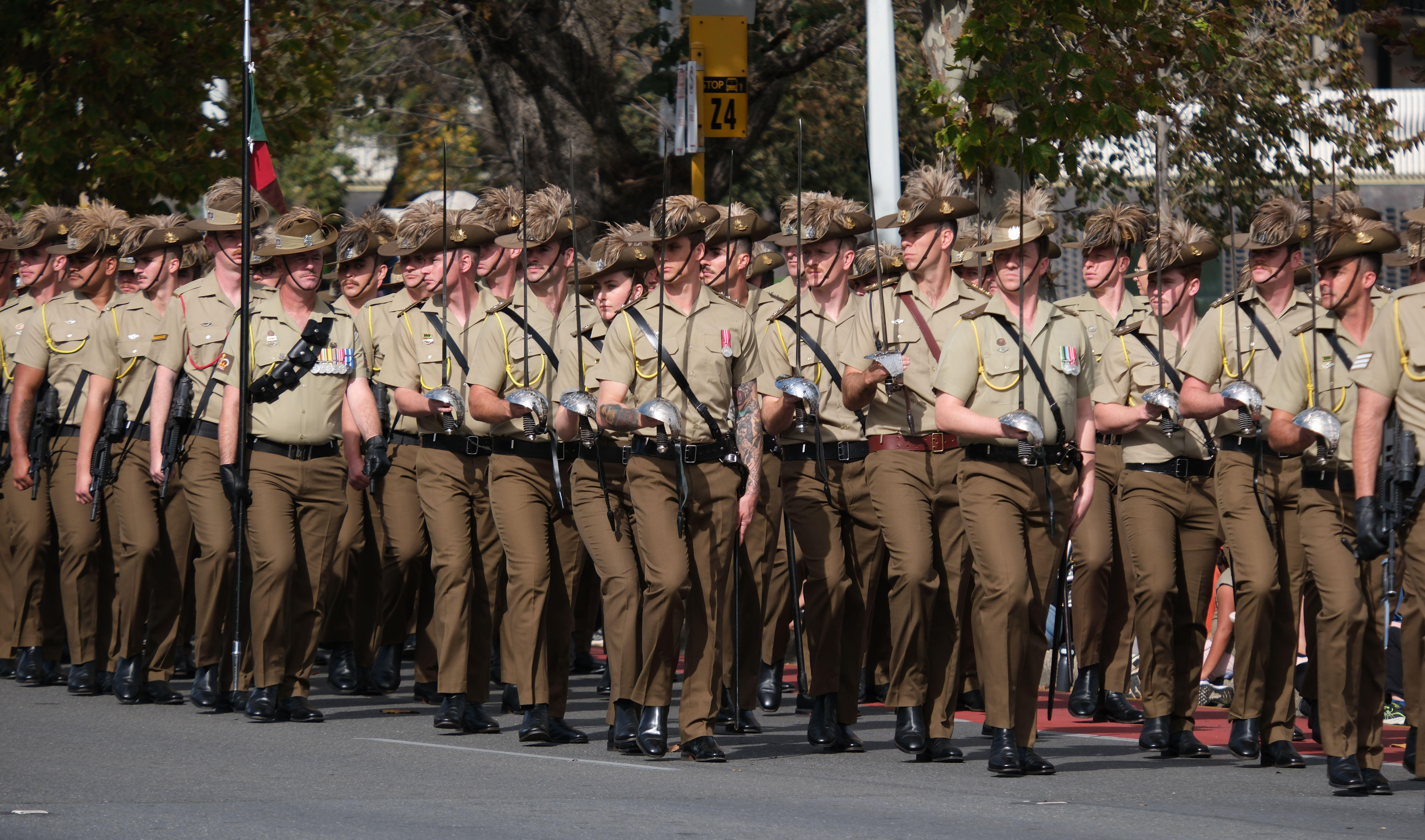 Soldiers march with swords in hand.
