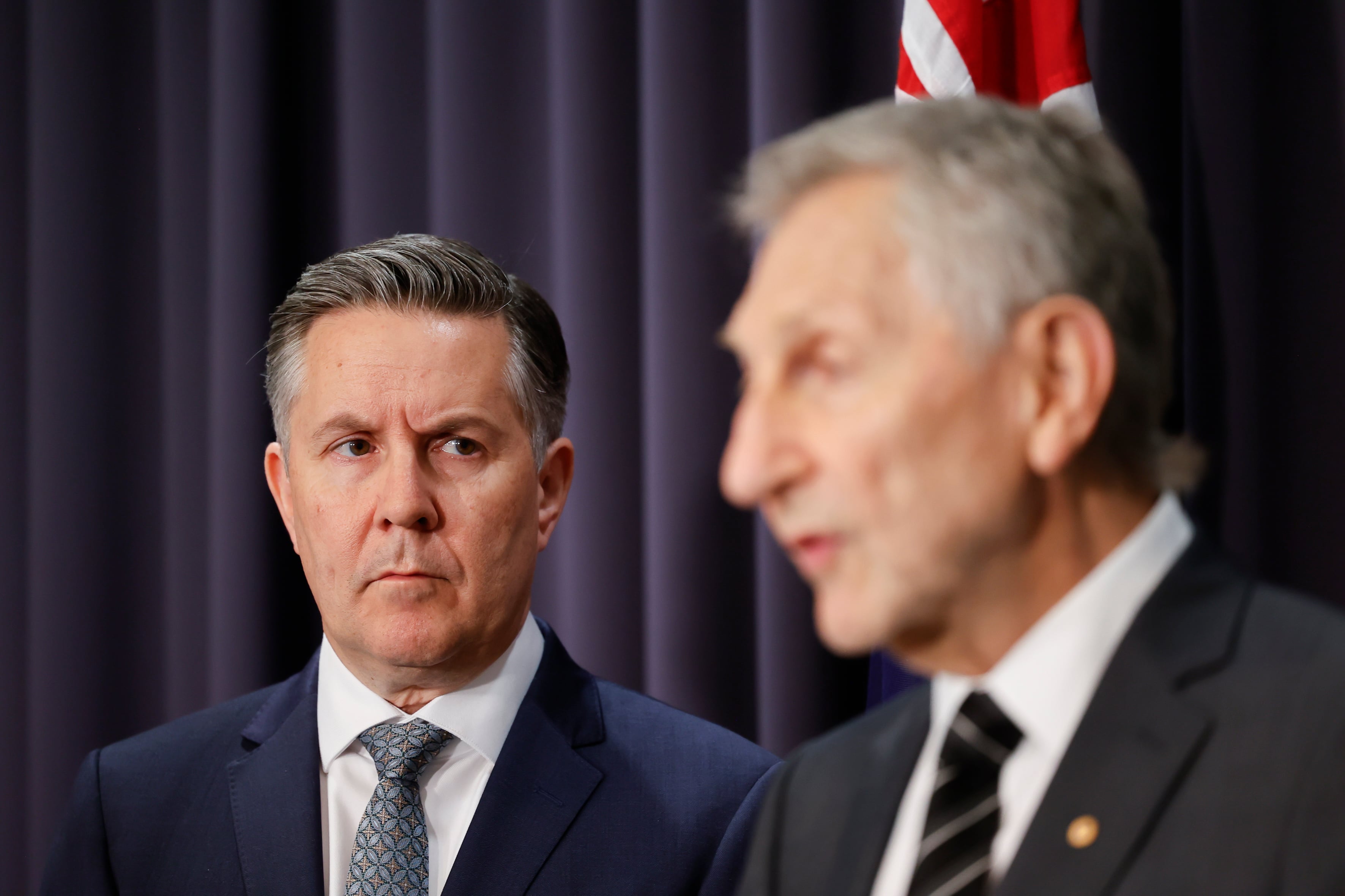 Mark Butler listens to Frank Oberklaid speak at a press conference.