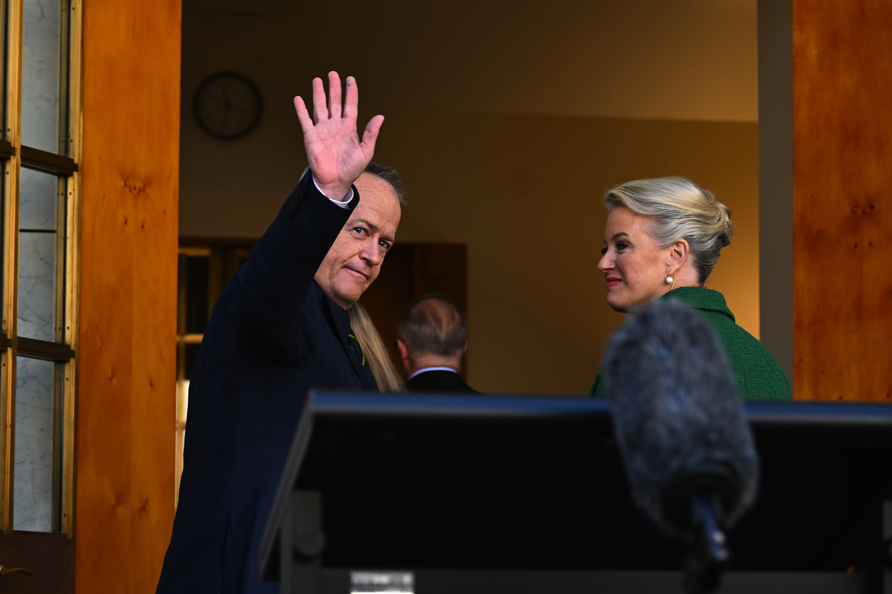 Bill Shorten stands beside wife Chloe Shorten and waves after announcing his exit from politics at Parliament House.