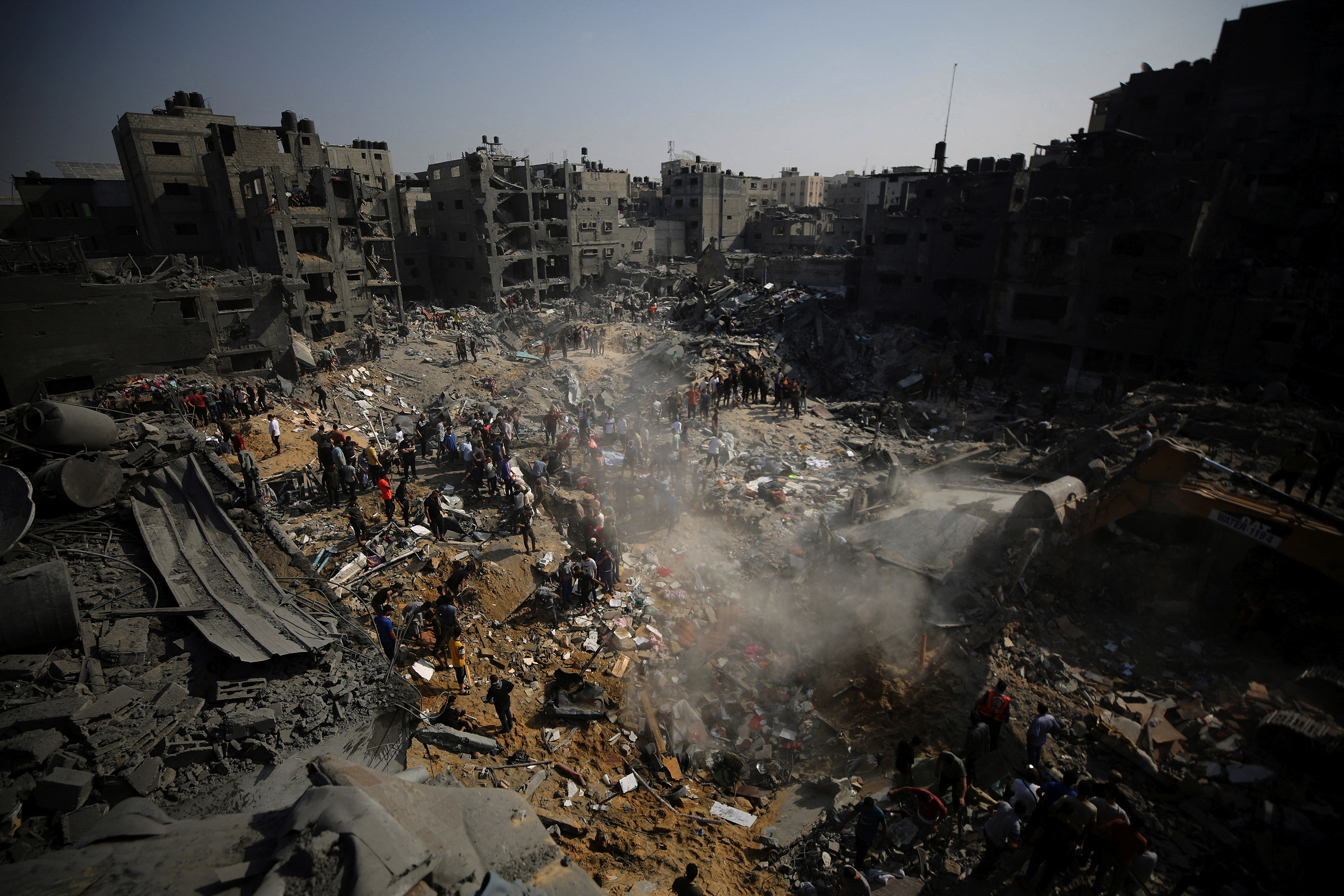 Palestinians search for casualties amongst the debris of a destroyed neighbourhood..
