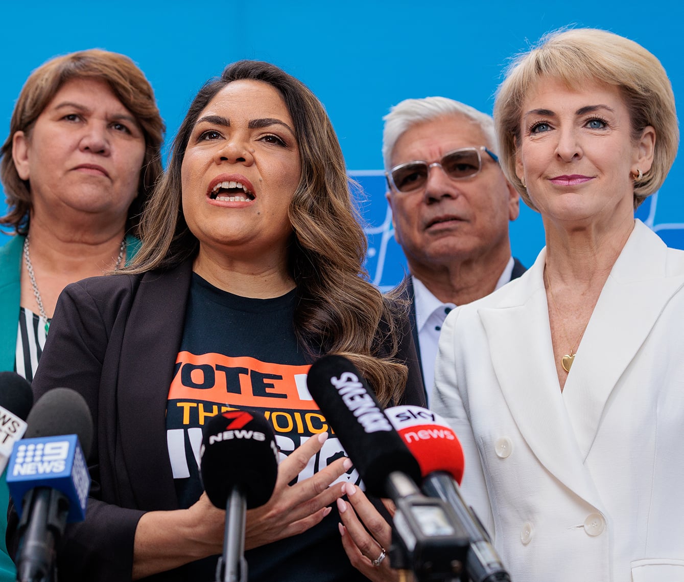Kerrynne Liddle, Jacinta Nampijinpa Price, Nyunggai Warren Mundine and Michaelia Cash speak behind microphones at a press conference.