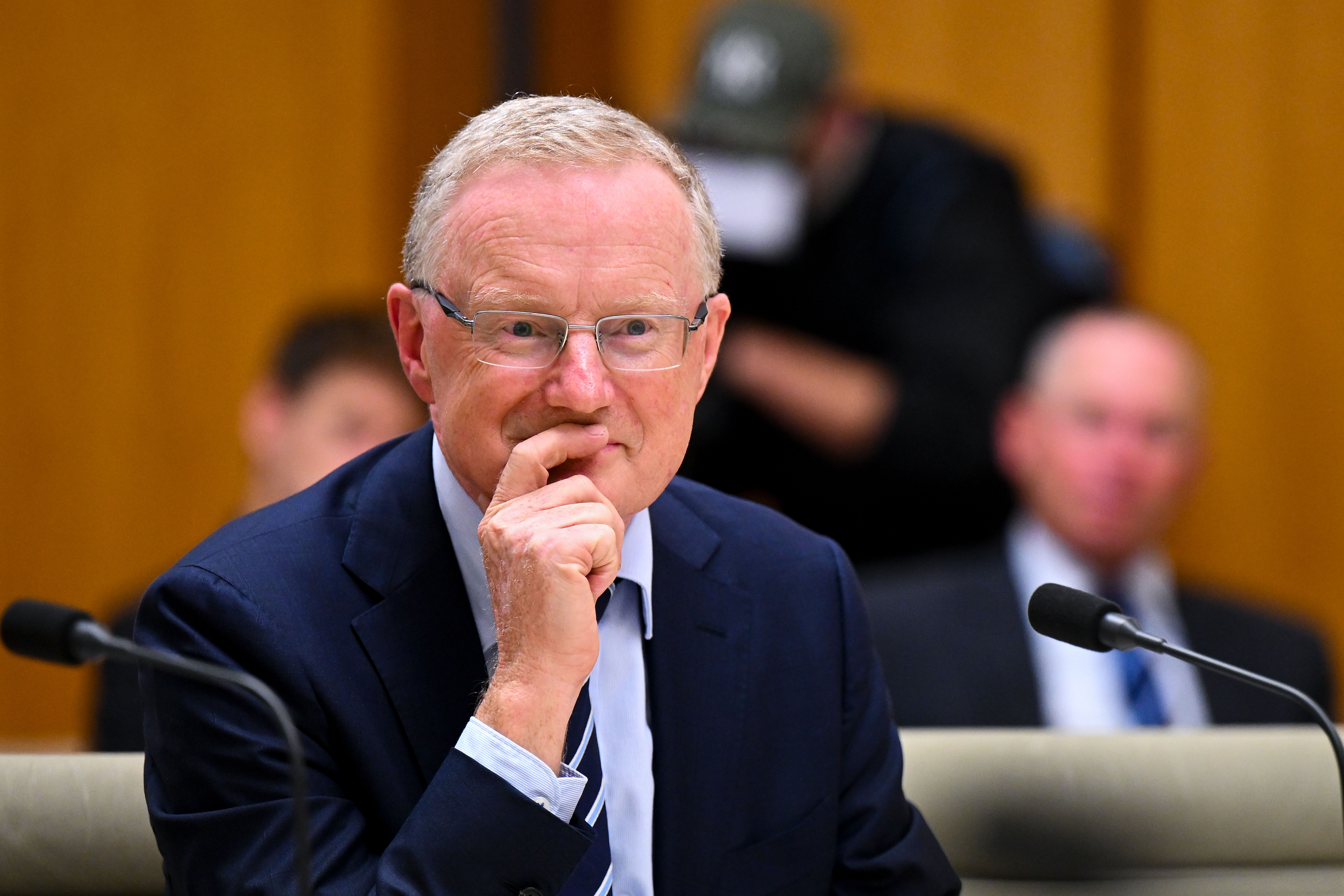 Governor of the Reserve Bank of Australia Philip Lowe, sitting in Parliament House beside a microphone.
