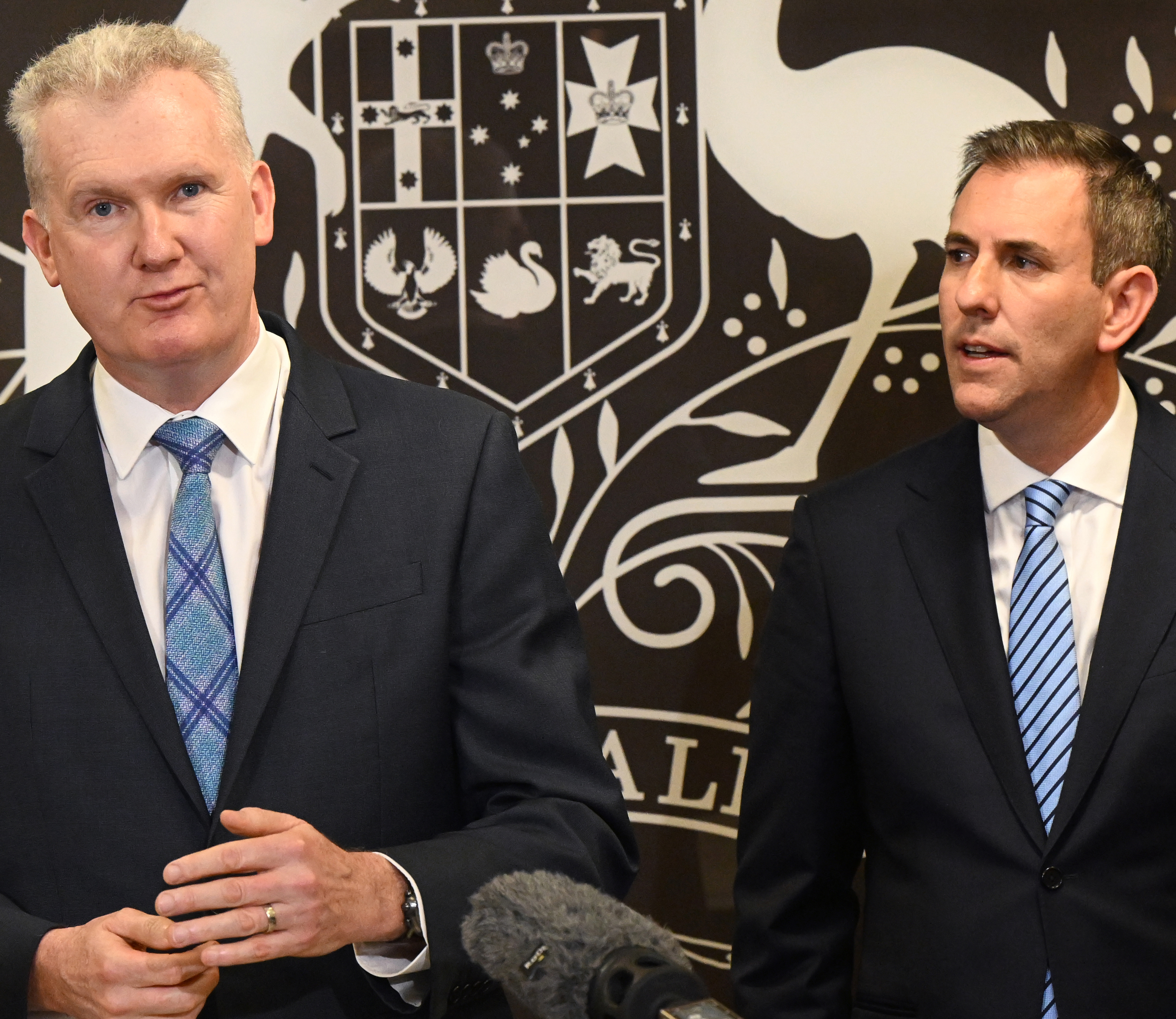 Minister for Employment and Workplace Relations Tony Burke (left) and Treasurer Jim Chalmers dressed in suits at a press conference.