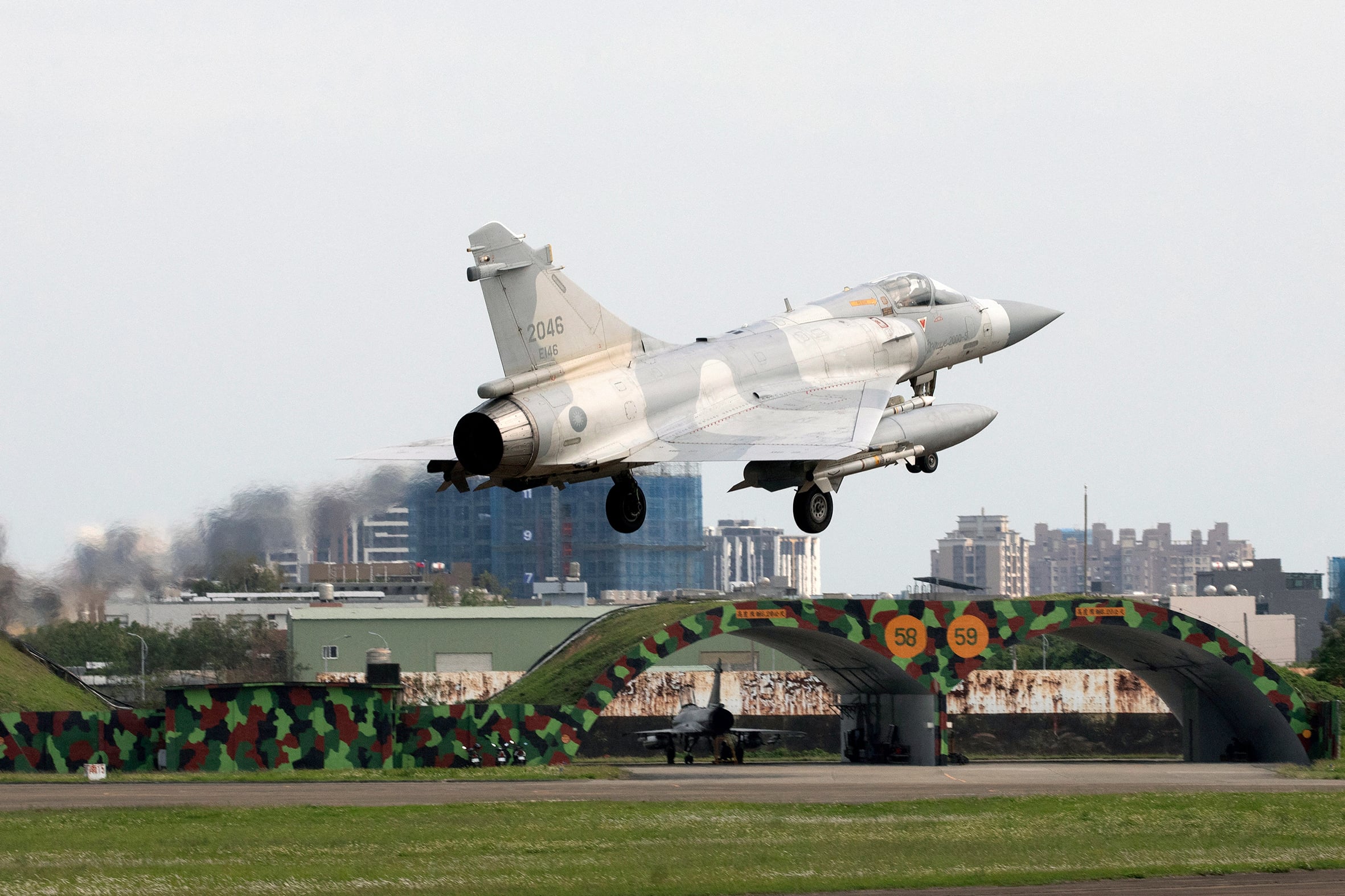 Mirage 2000 fighter jet taking off at a military base.