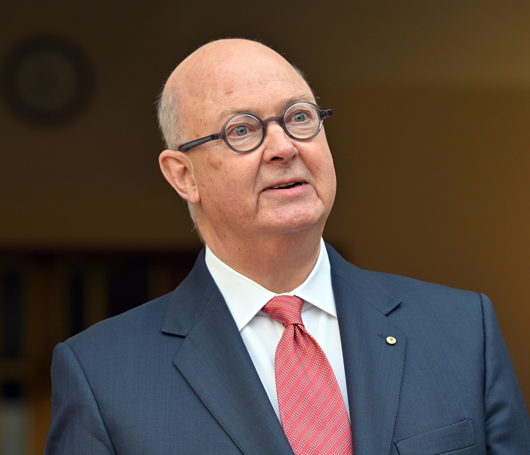 Kim Williams wearing glasses and a suit.