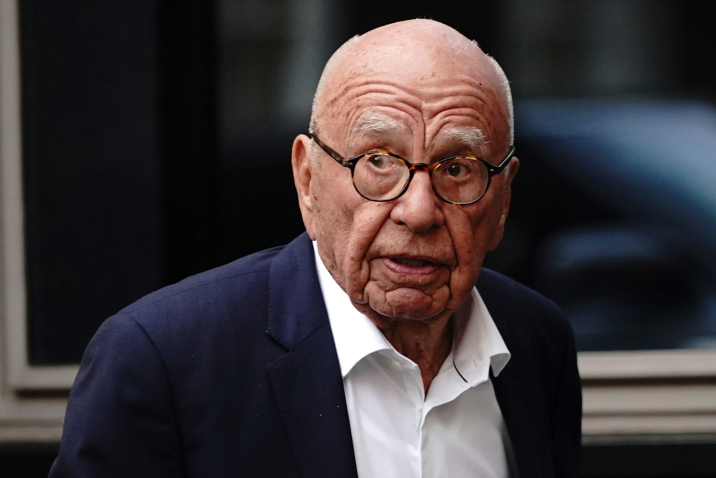Rupert Murdoch wearing a suit and glasses.