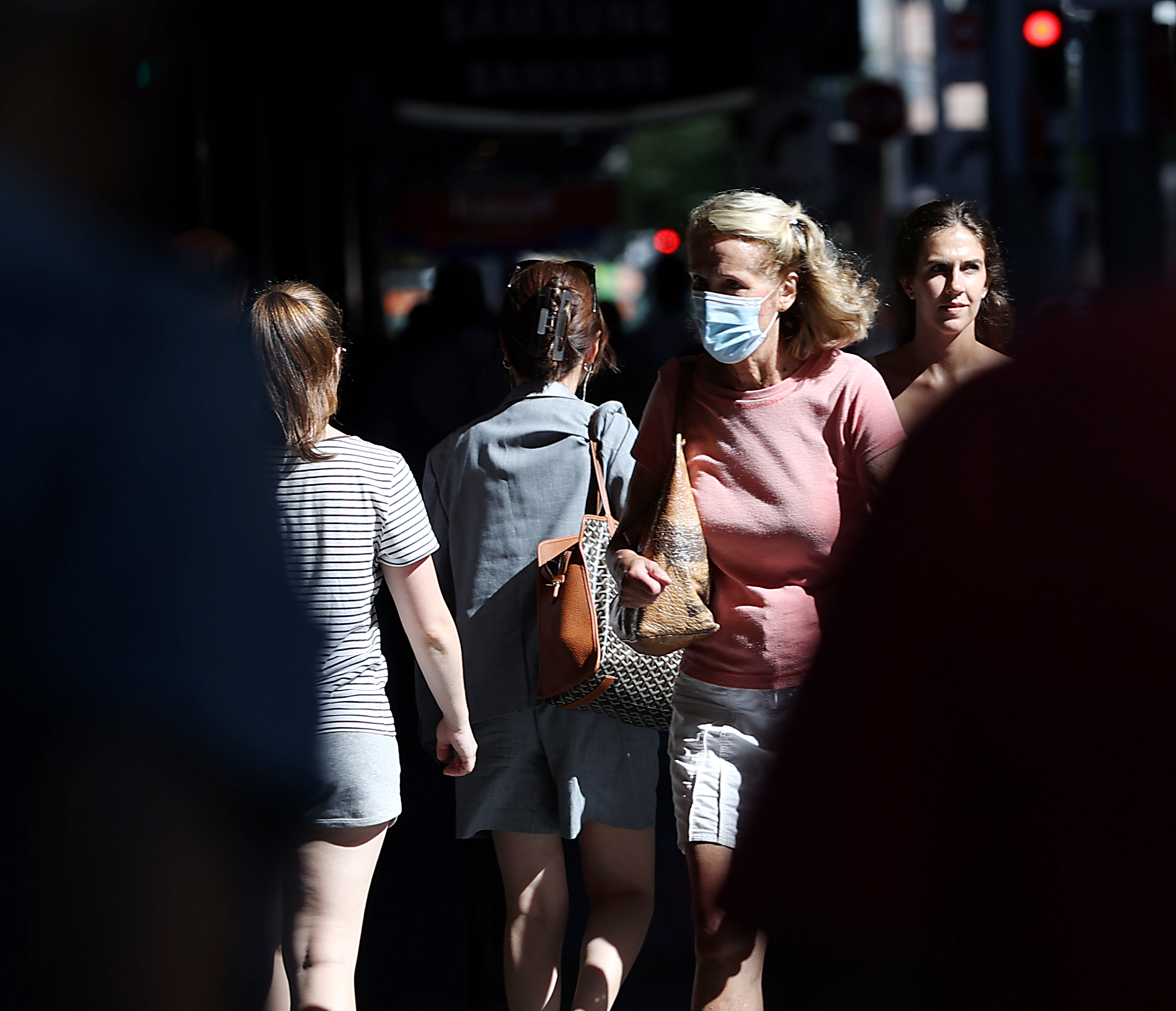 A woman wears a mask on a Sydney street. 