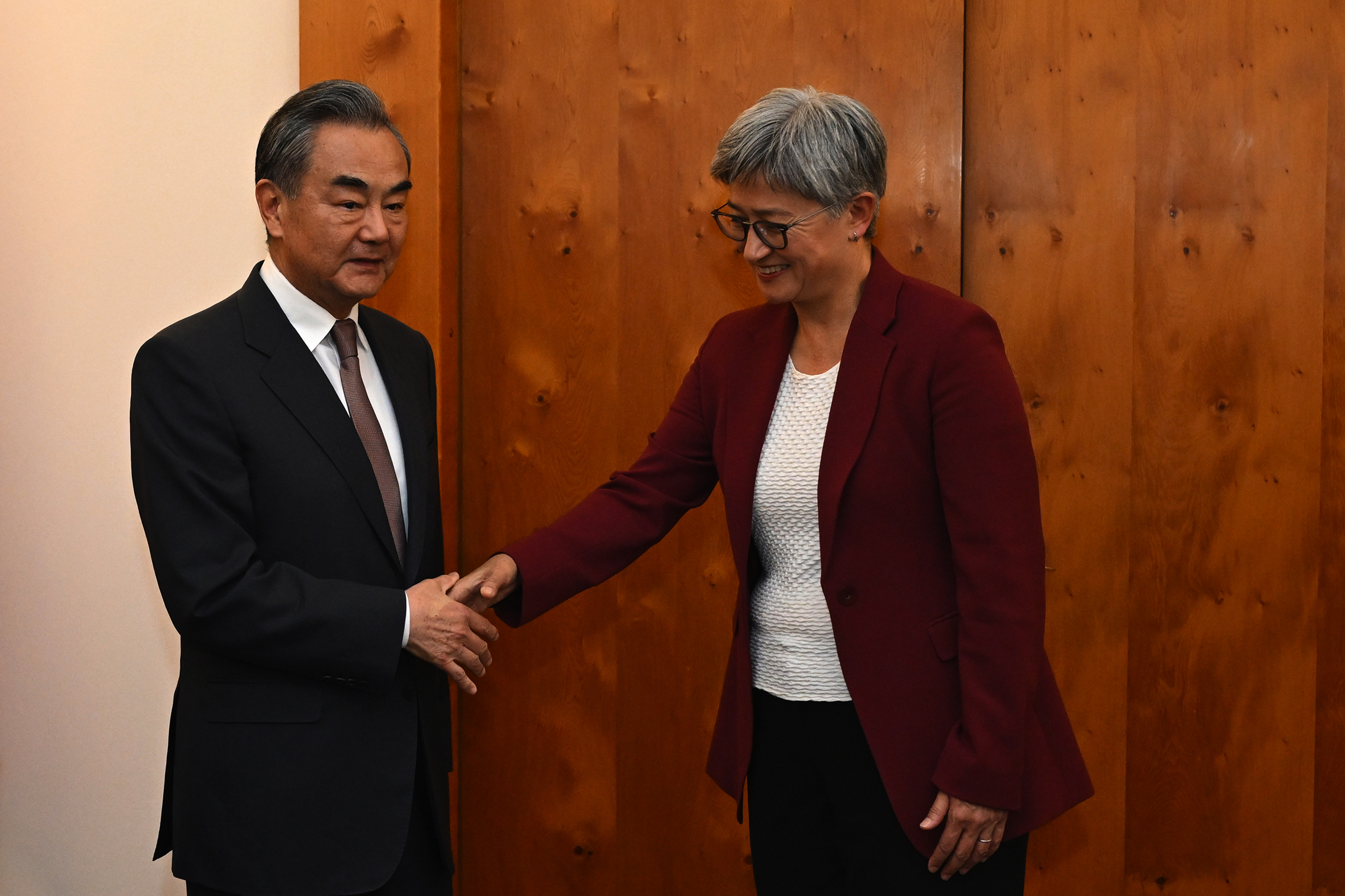 Penny Wong and Wang Yi shake hands.