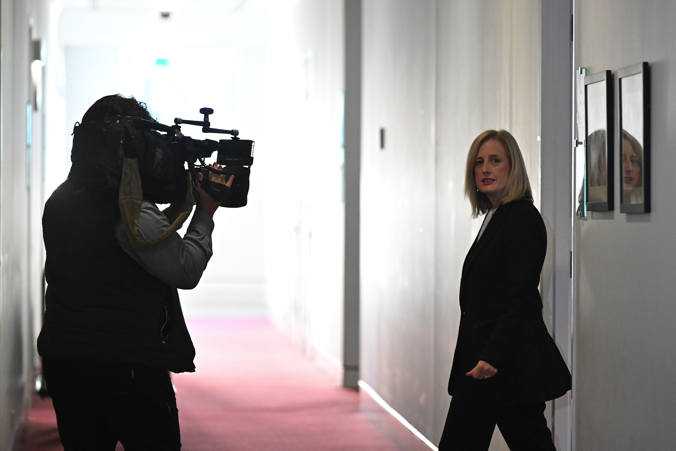 Katy Gallagher in a Parliament House hallway being followed by a cameraman.