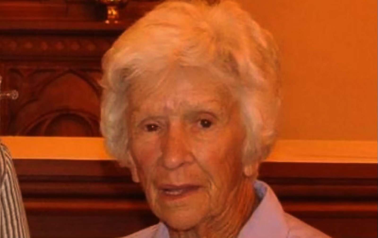 An elderly woman with short grey hair.