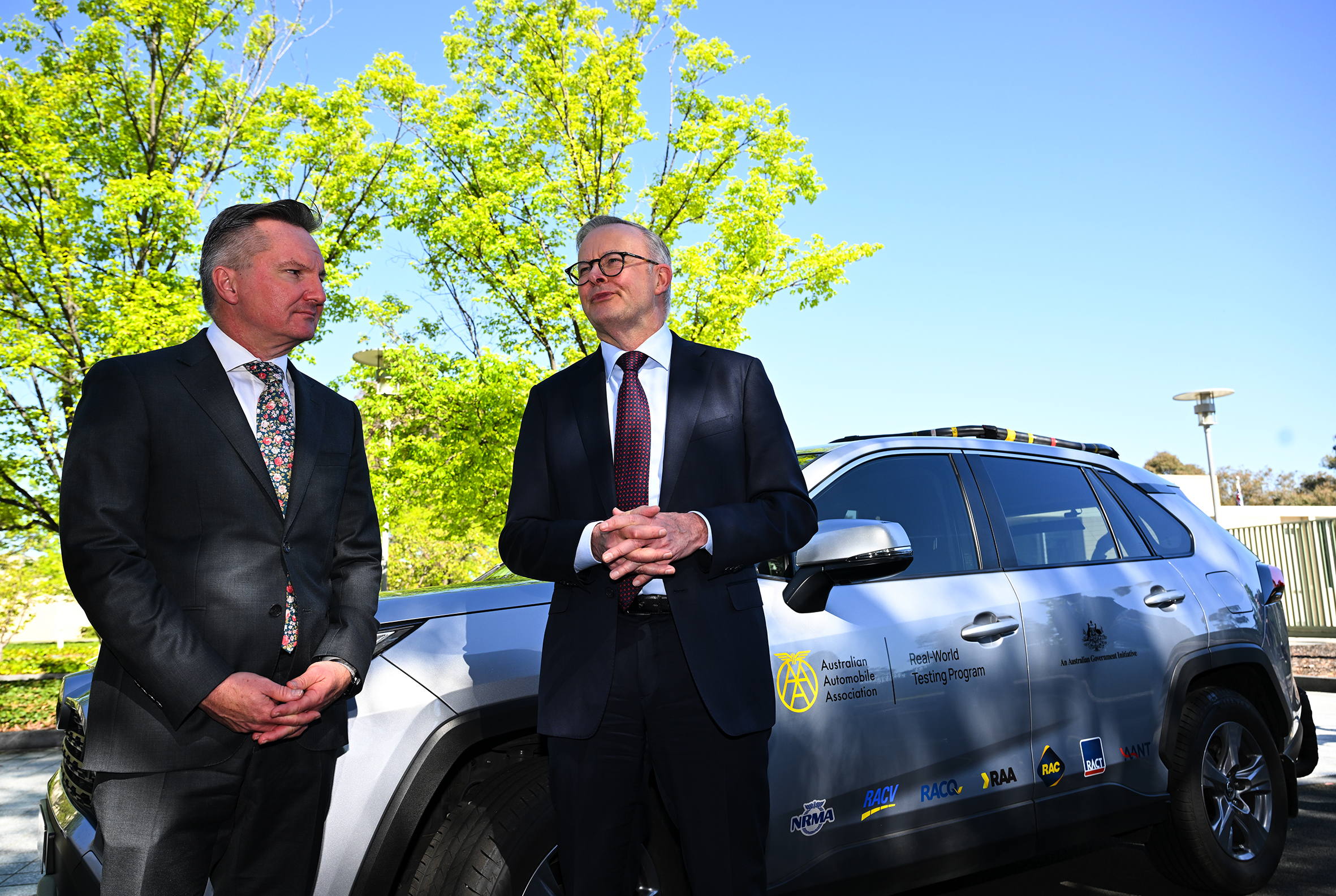 Anthony Albanese and Chris Bowen standing beside a silver car.