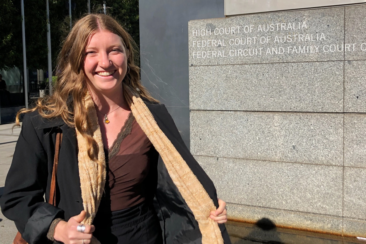 A woman smiles outside the High Court.