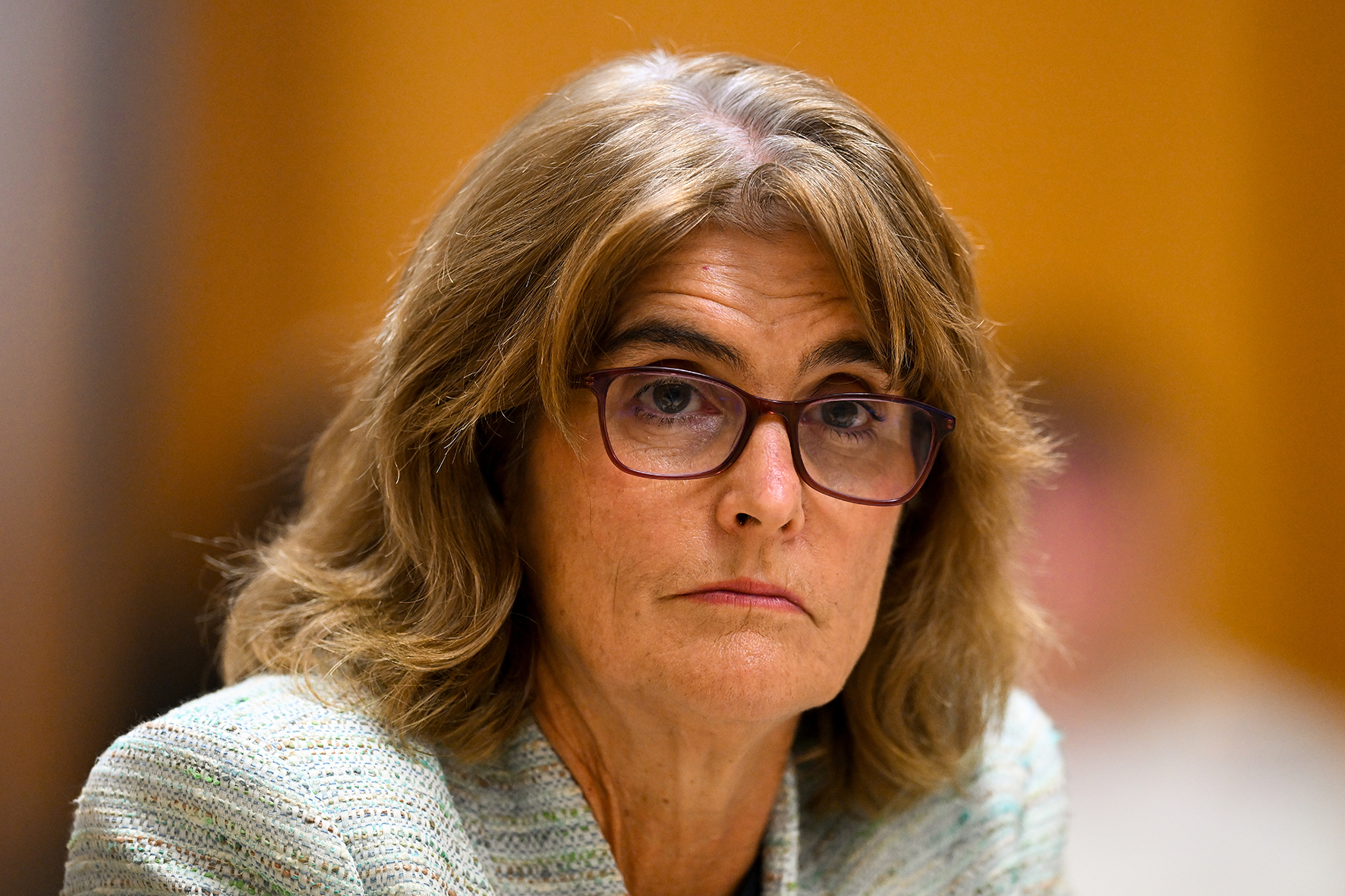 A woman with shoulder-length hair and glasses.