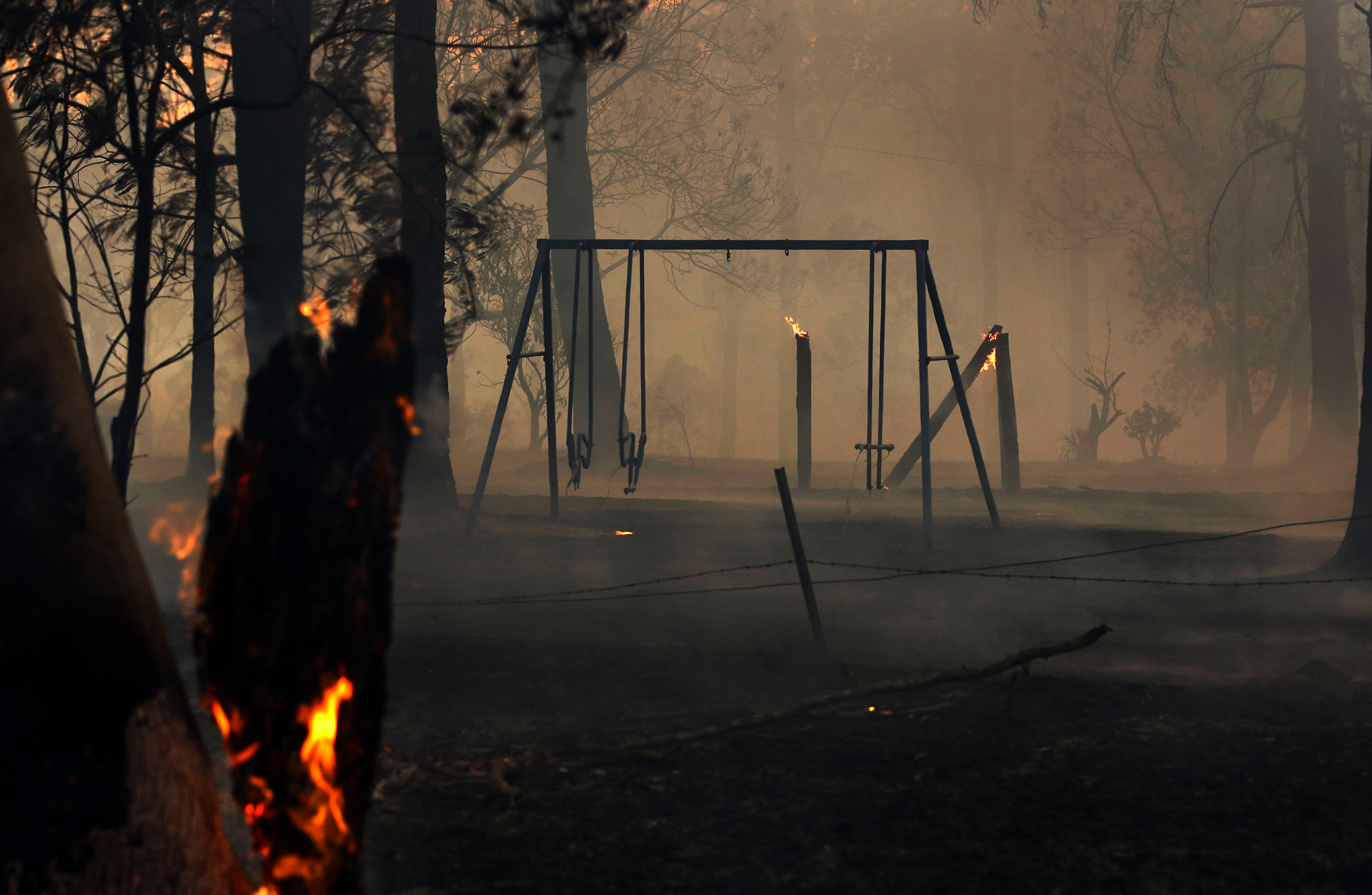 A playground reduced to ash amongst a bushfire.