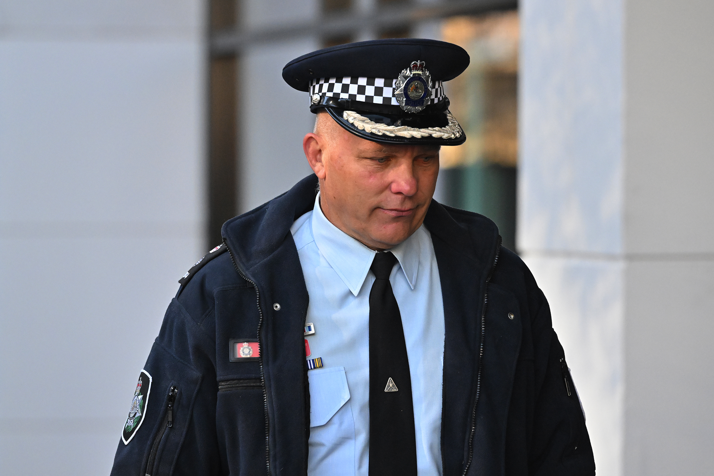 A police officer in uniform outside a courthouse. 