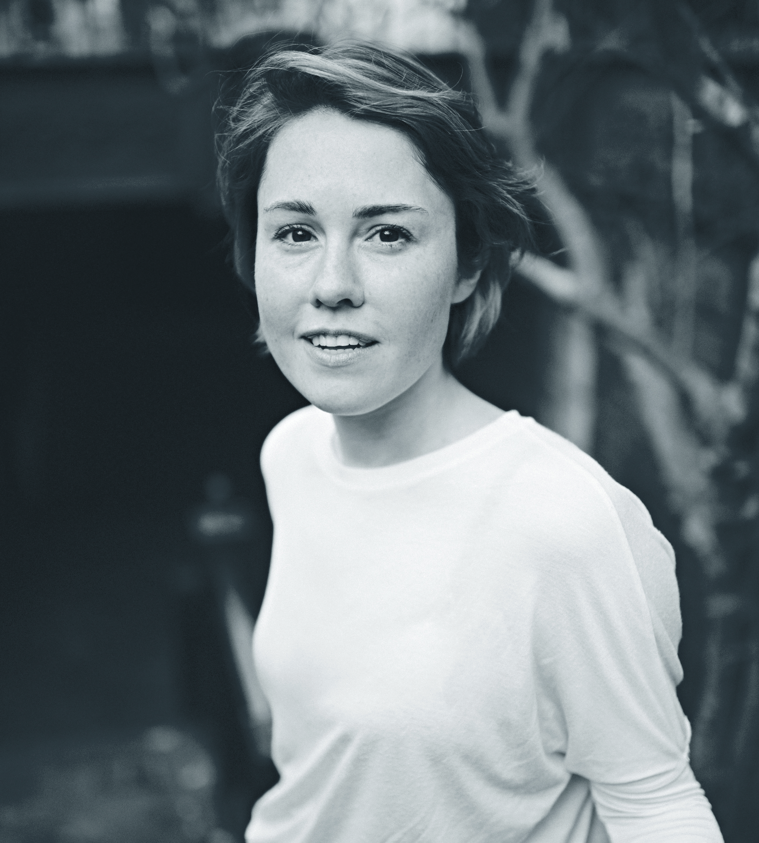 Greyscale portrait image of a young woman with short hair.