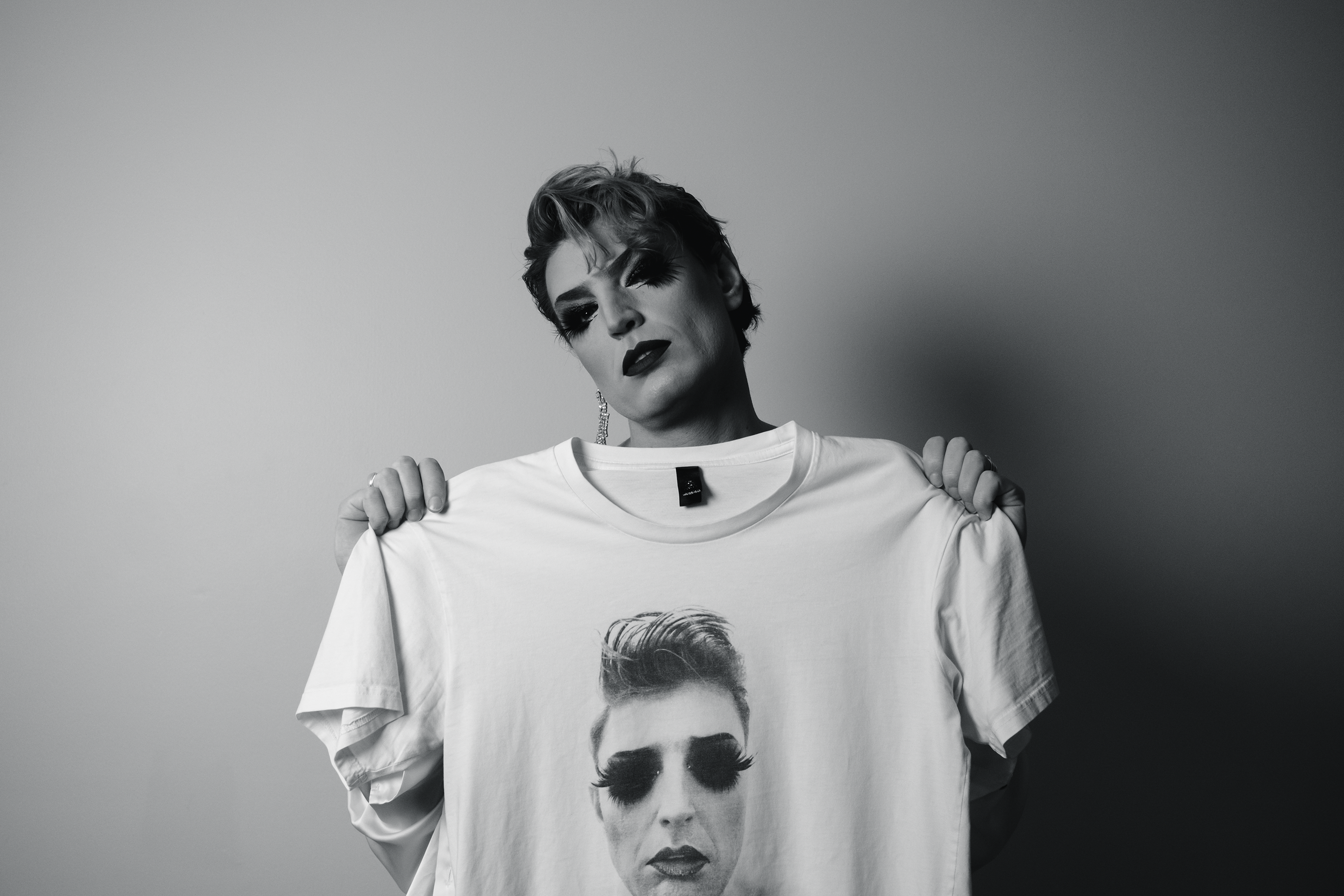 Reuben Kaye holding a t-shirt with his face printed on the front.