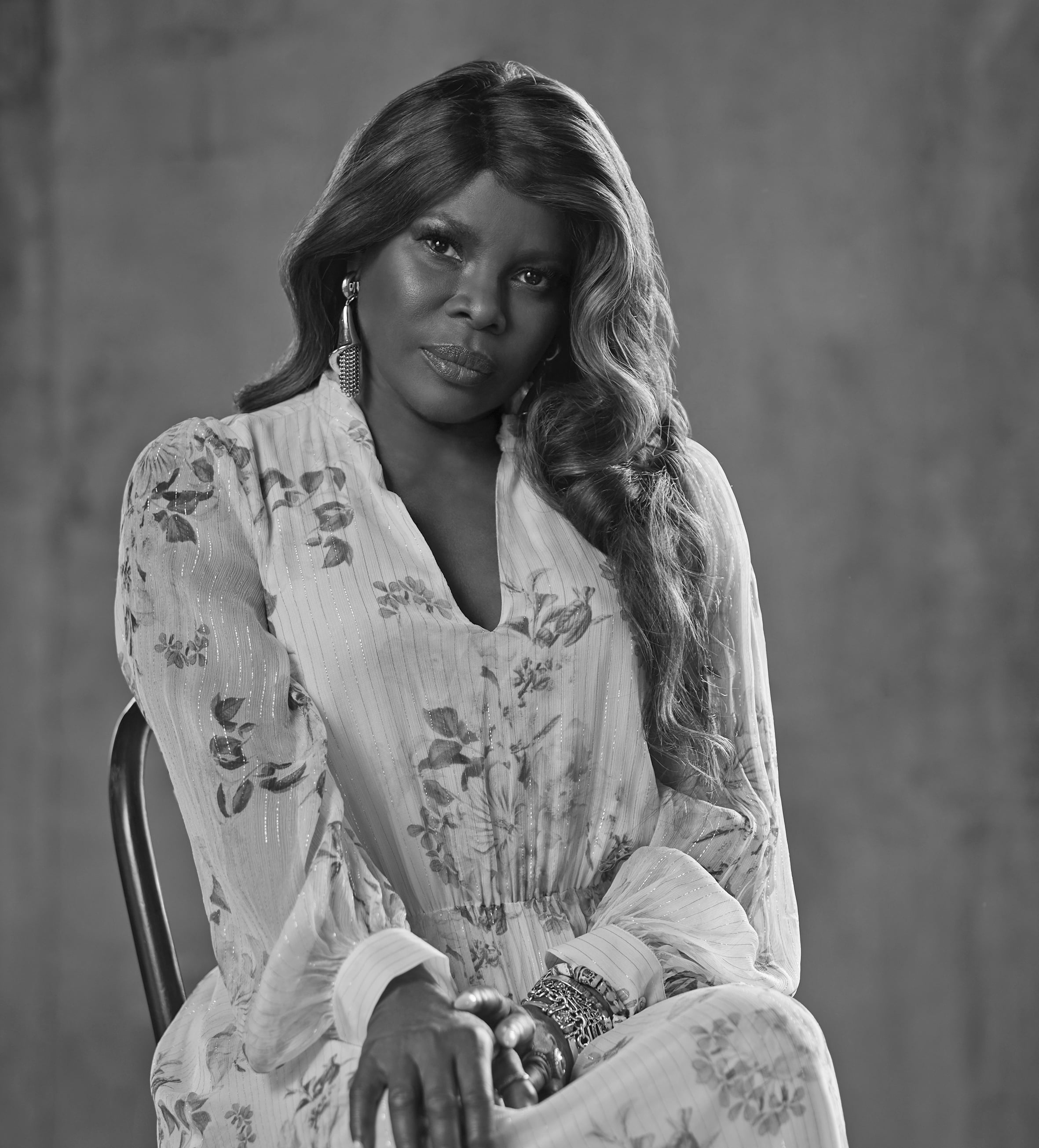 Greyscale image of a woman with long hair and wearing a white dress.