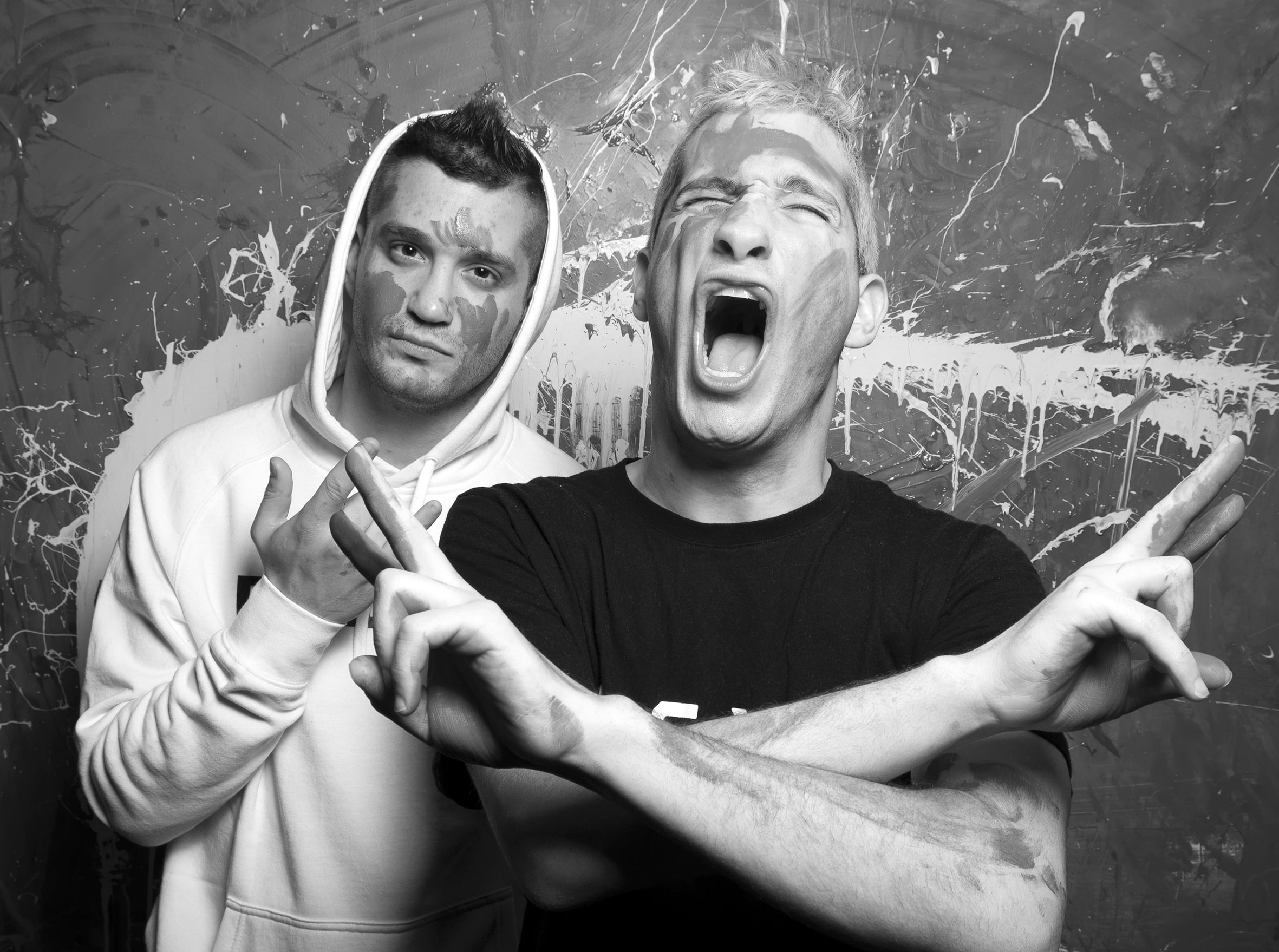 Two men with face paint striking "rock on" poses.