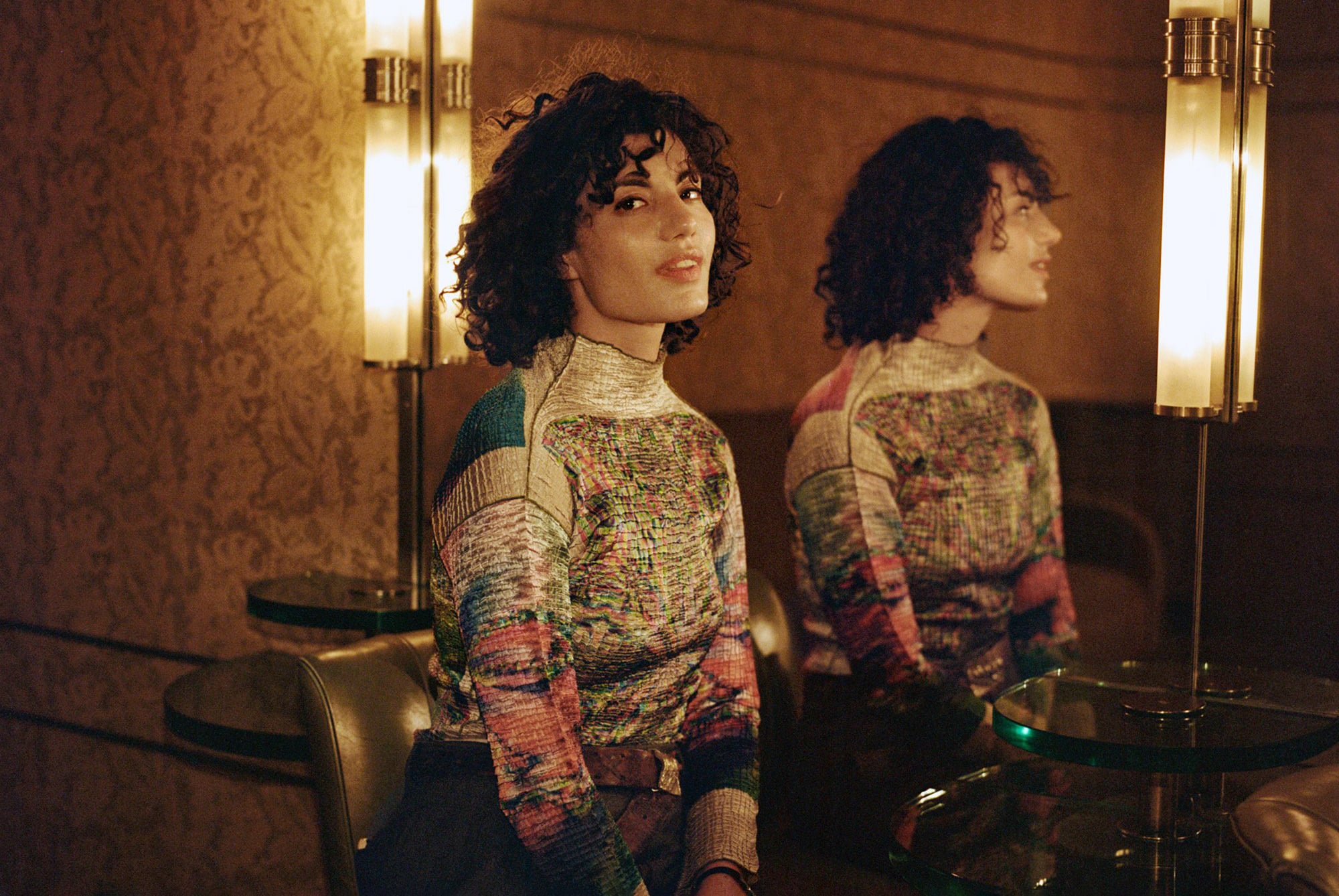 A young woman with dark, curly hair.