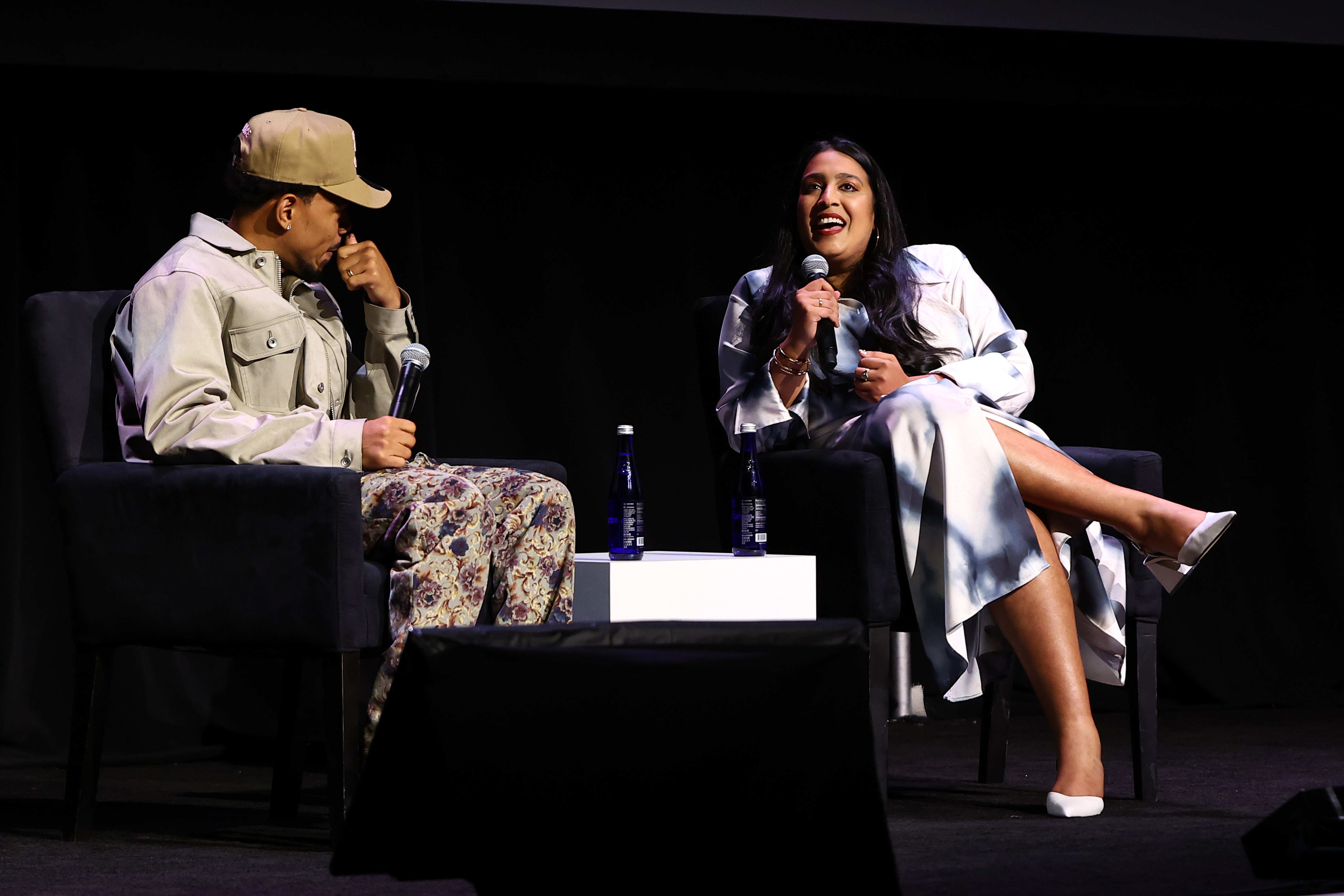 Two people in conversation with microphones in their hands.