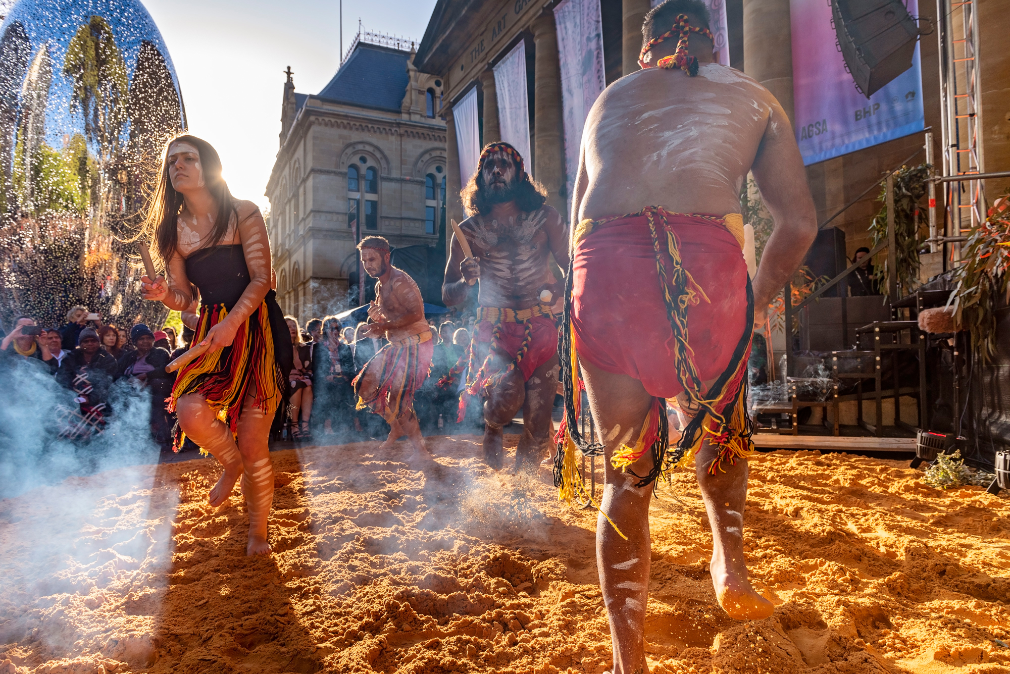 Kaurna dance group Kuma Kaaru performs to a street crowd. 
