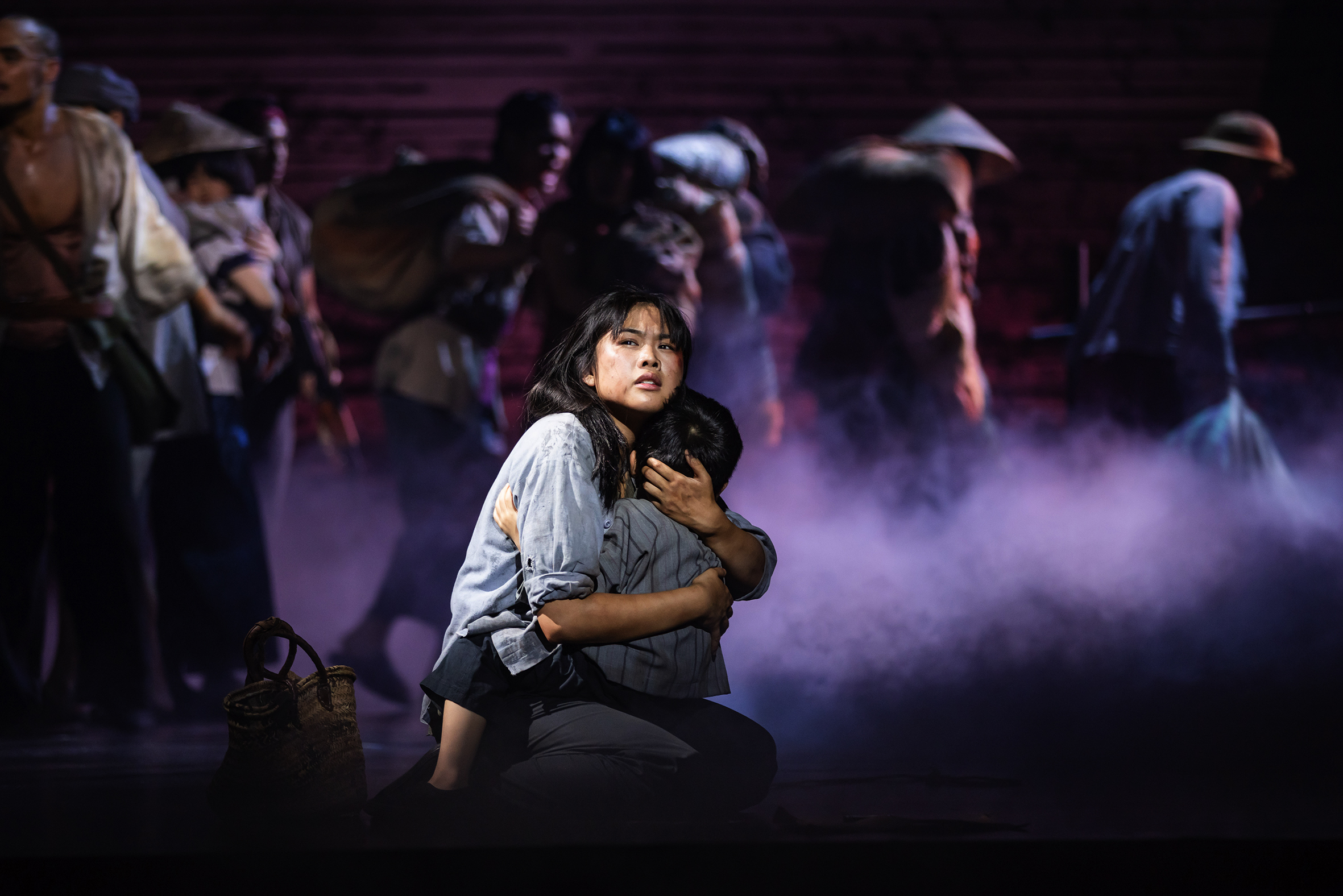 A performer holds a child in her arms on stage.