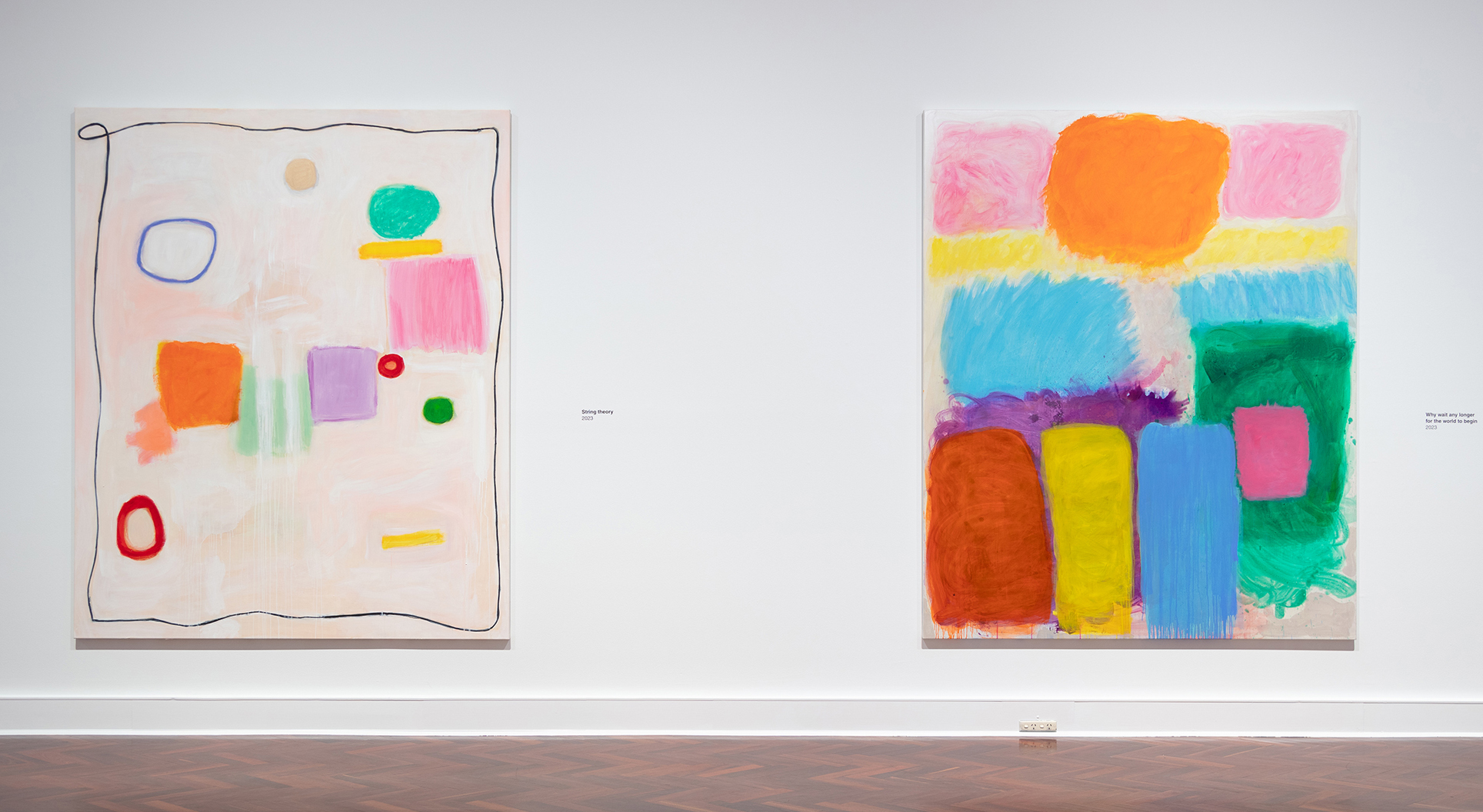 Two paintings on exhibit in a gallery.