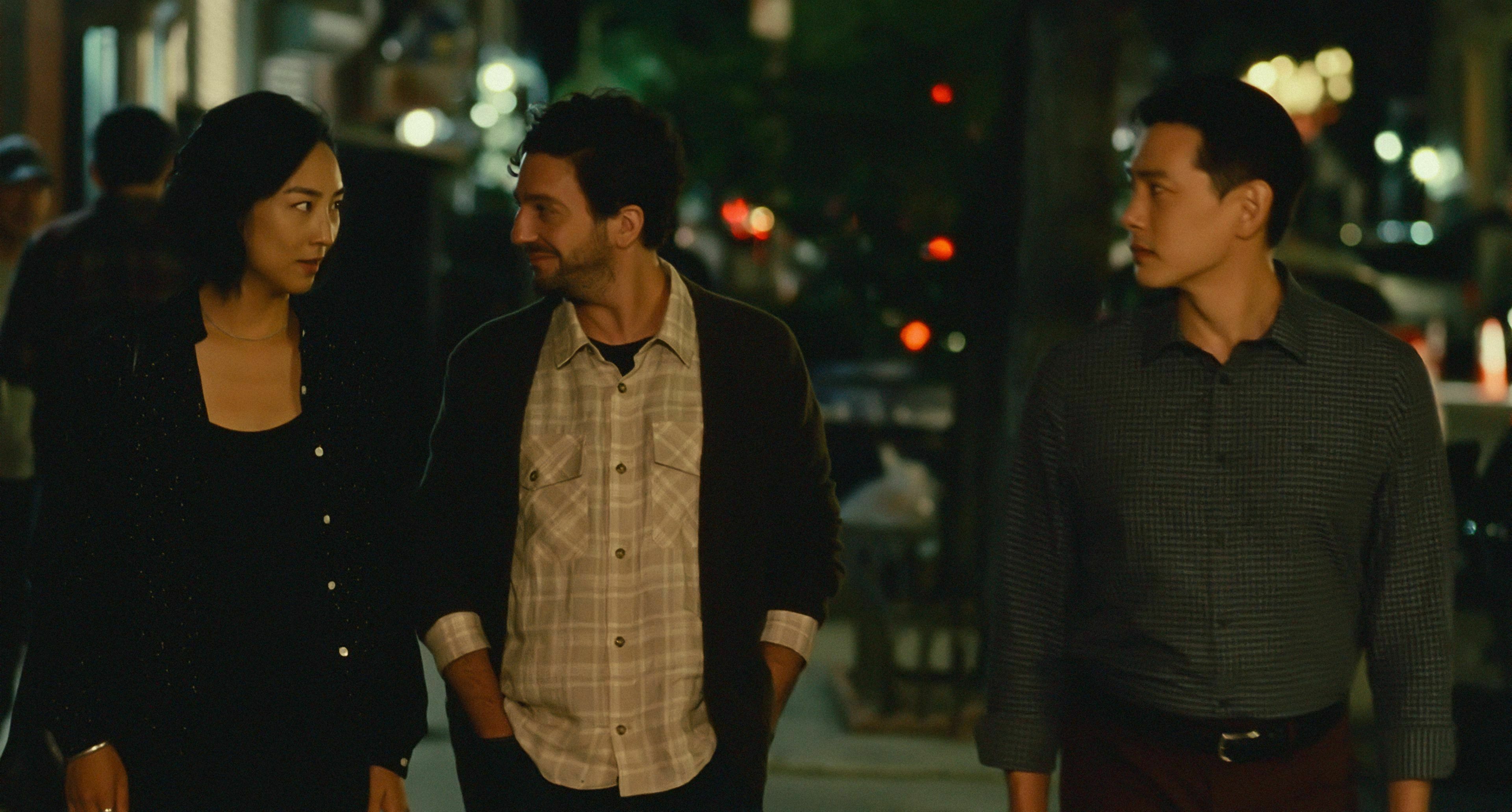 Three people in smart-casual dress walk down a New York street.