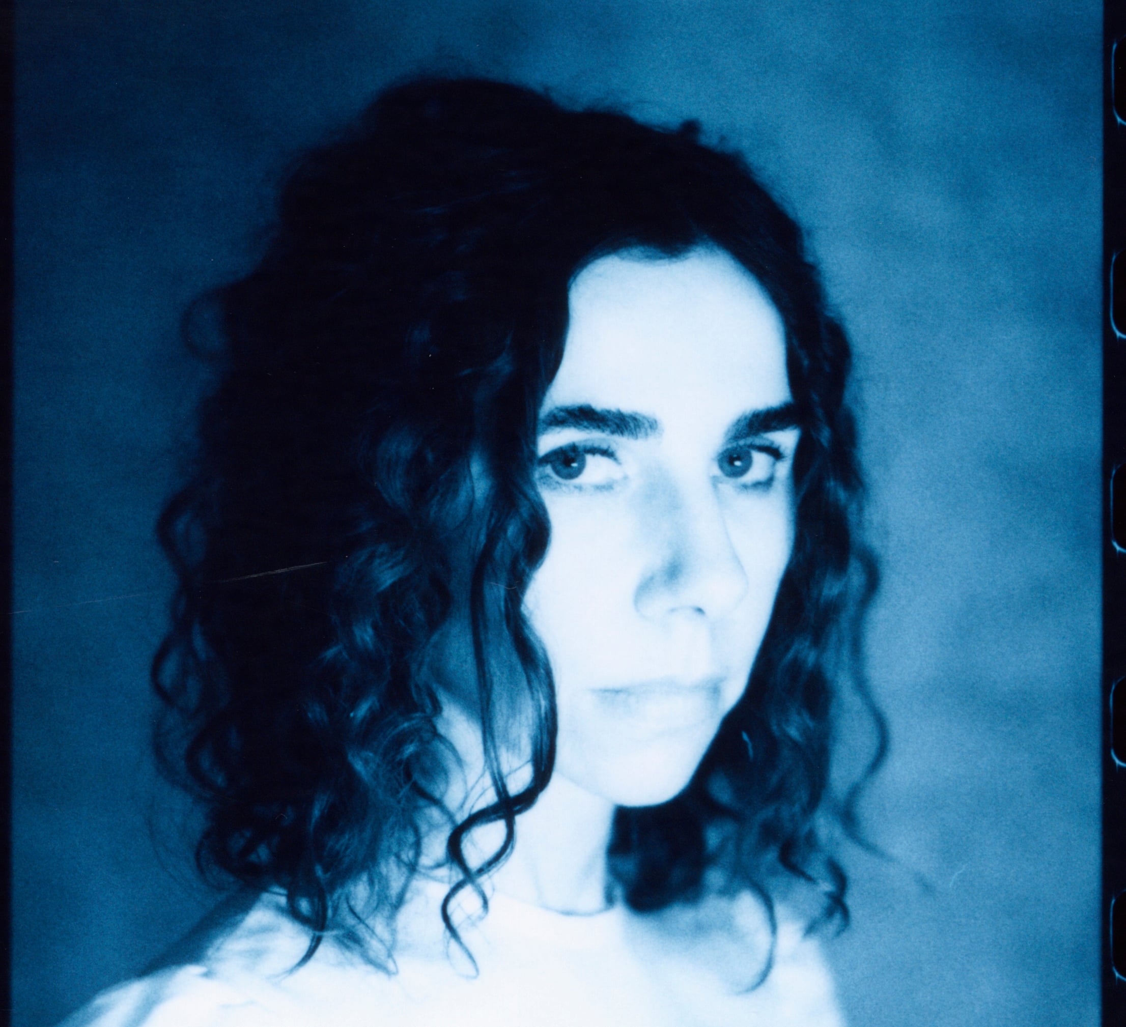 Portrait black and white image of a pale woman with dark hair. 