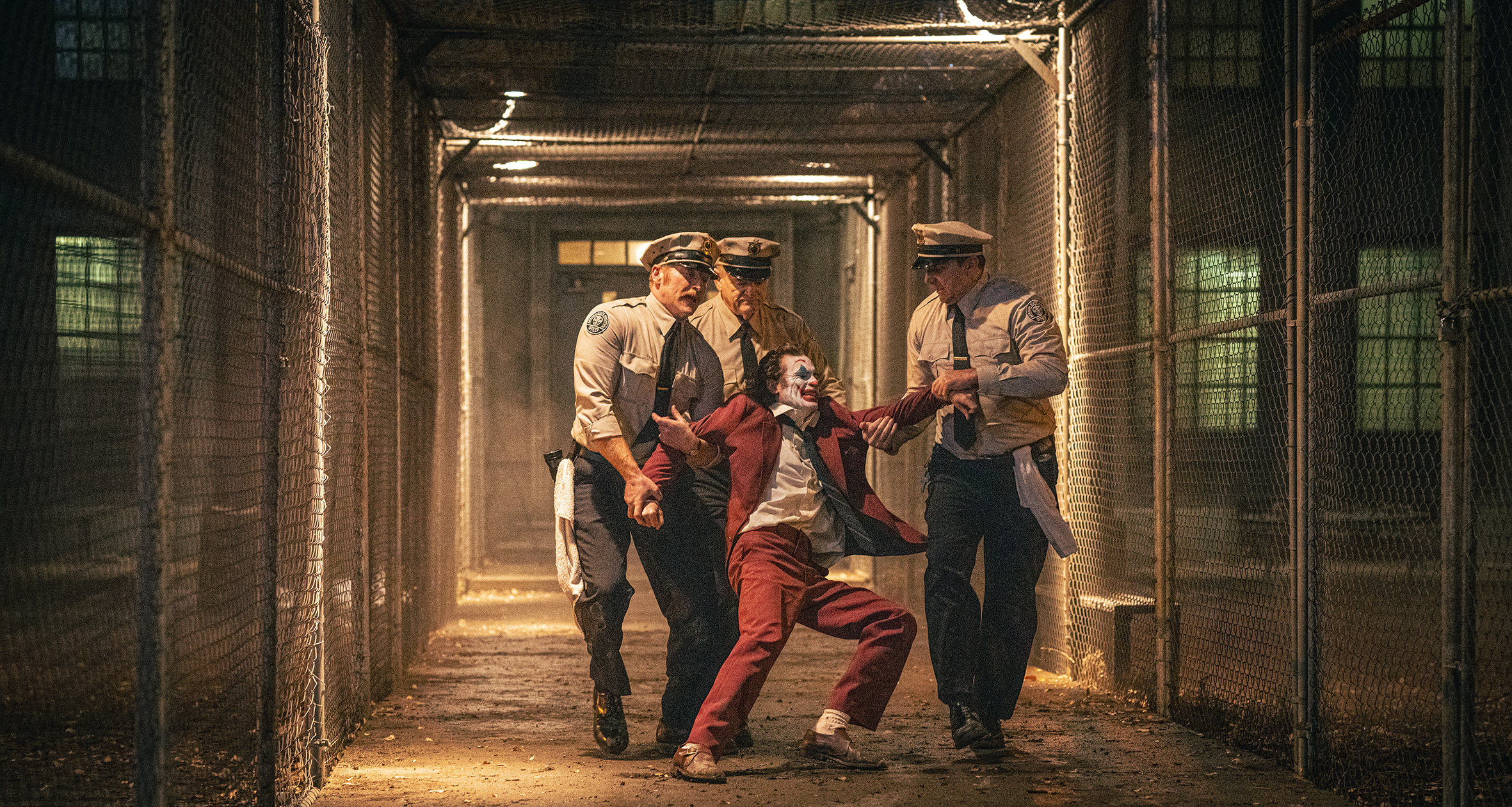 Joker being dragged by several policemen.