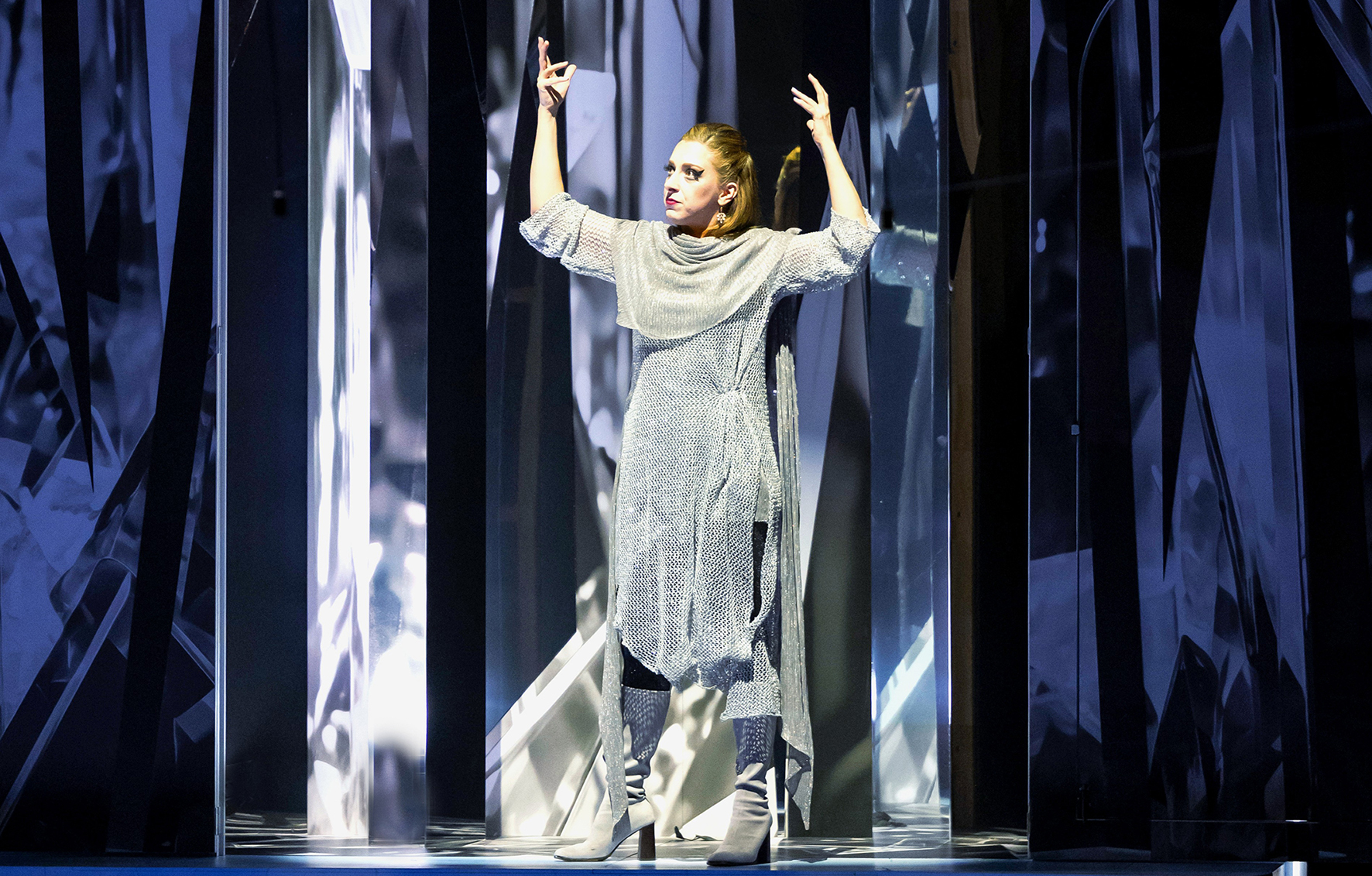 A performer on stage with their hands raised.