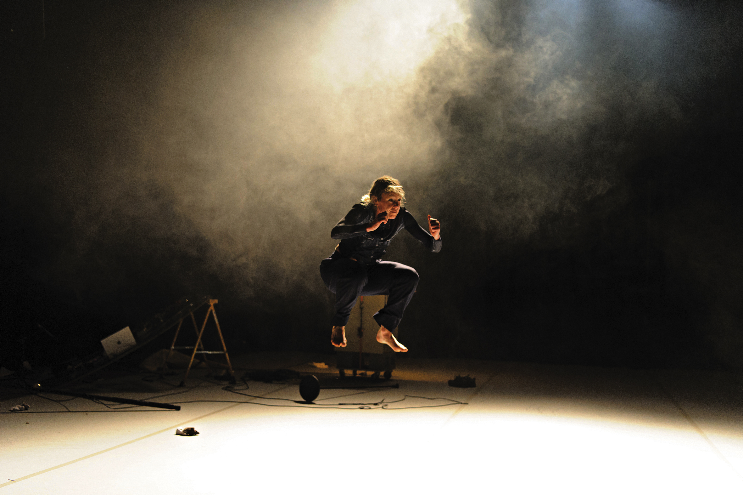 A performer jumps under a spotlight.