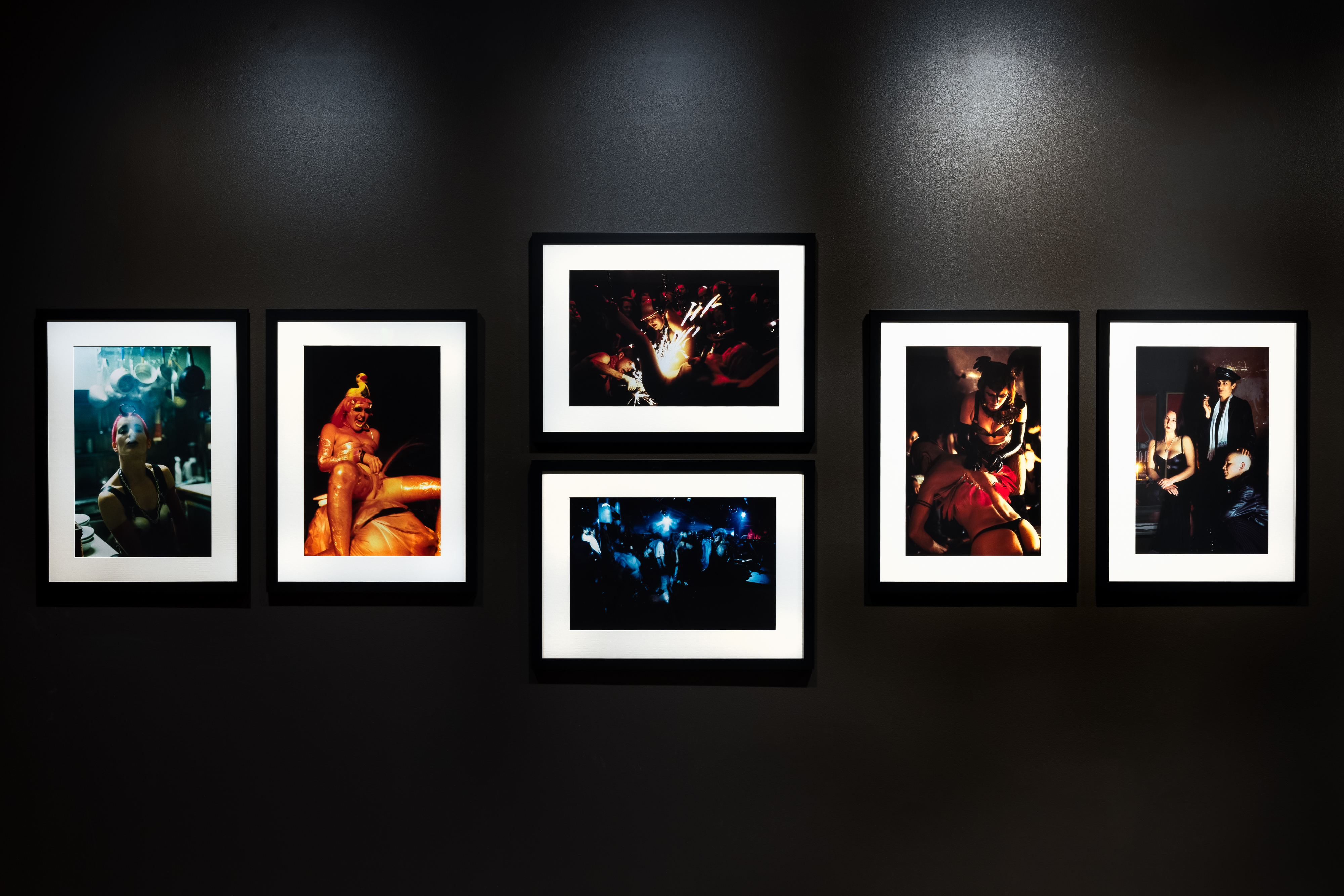 An installation shot of photos framed on a black wall. 