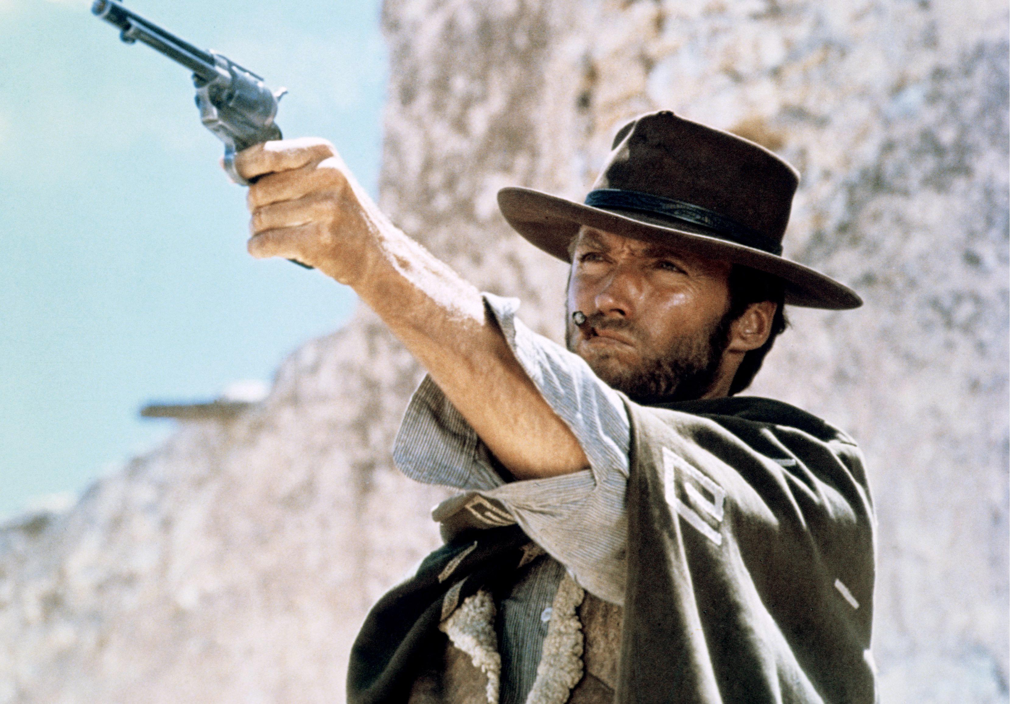 Clint Eastwood in cowboy clothing and holding a pistol.