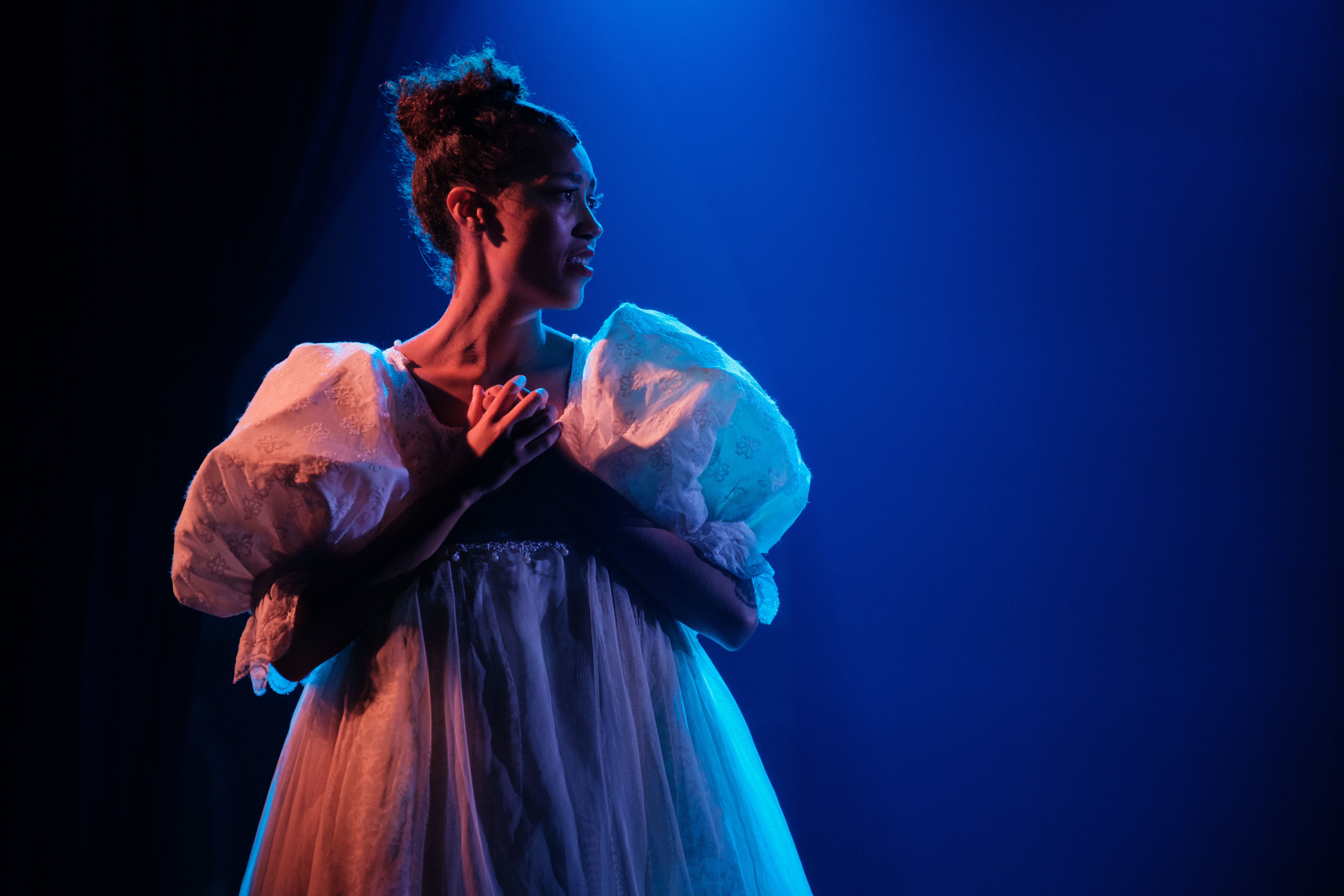 A performer on stage in a white gown.