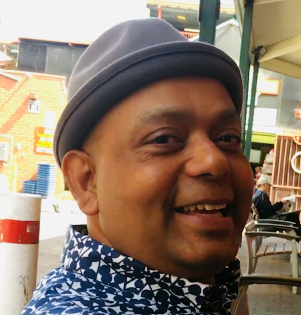 A smiling middle-aged man wearing a hat.