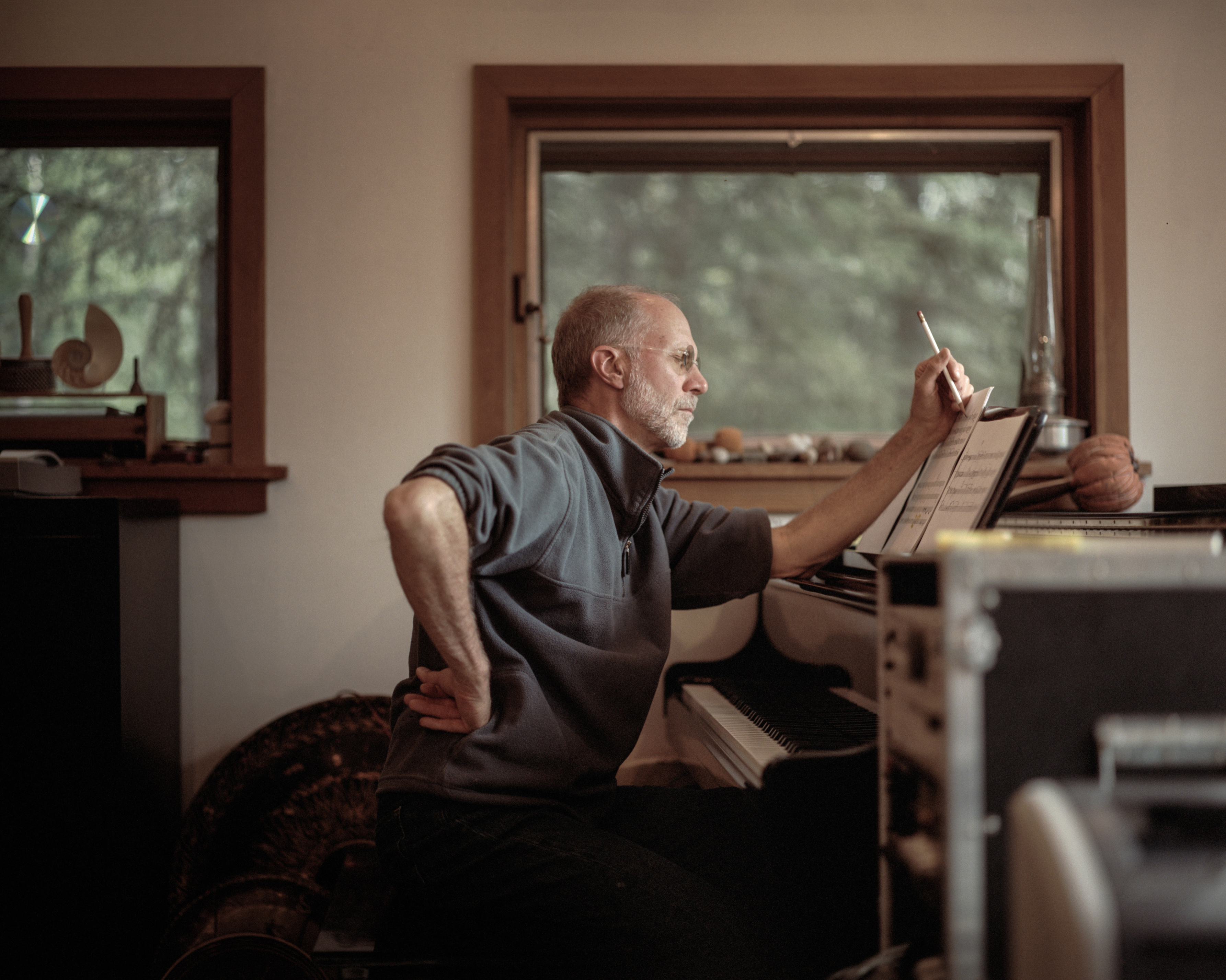 Composer John Luther Adams sits at a piano.