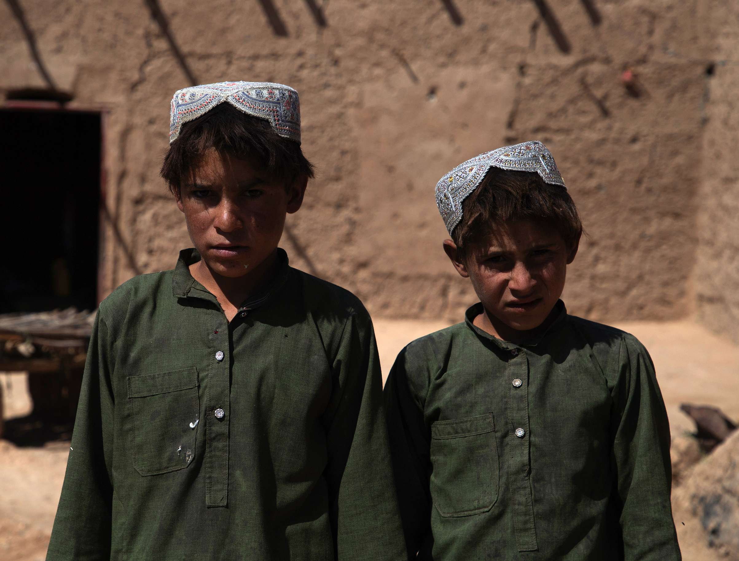 Two young boys outside their home in Afghanistan. 