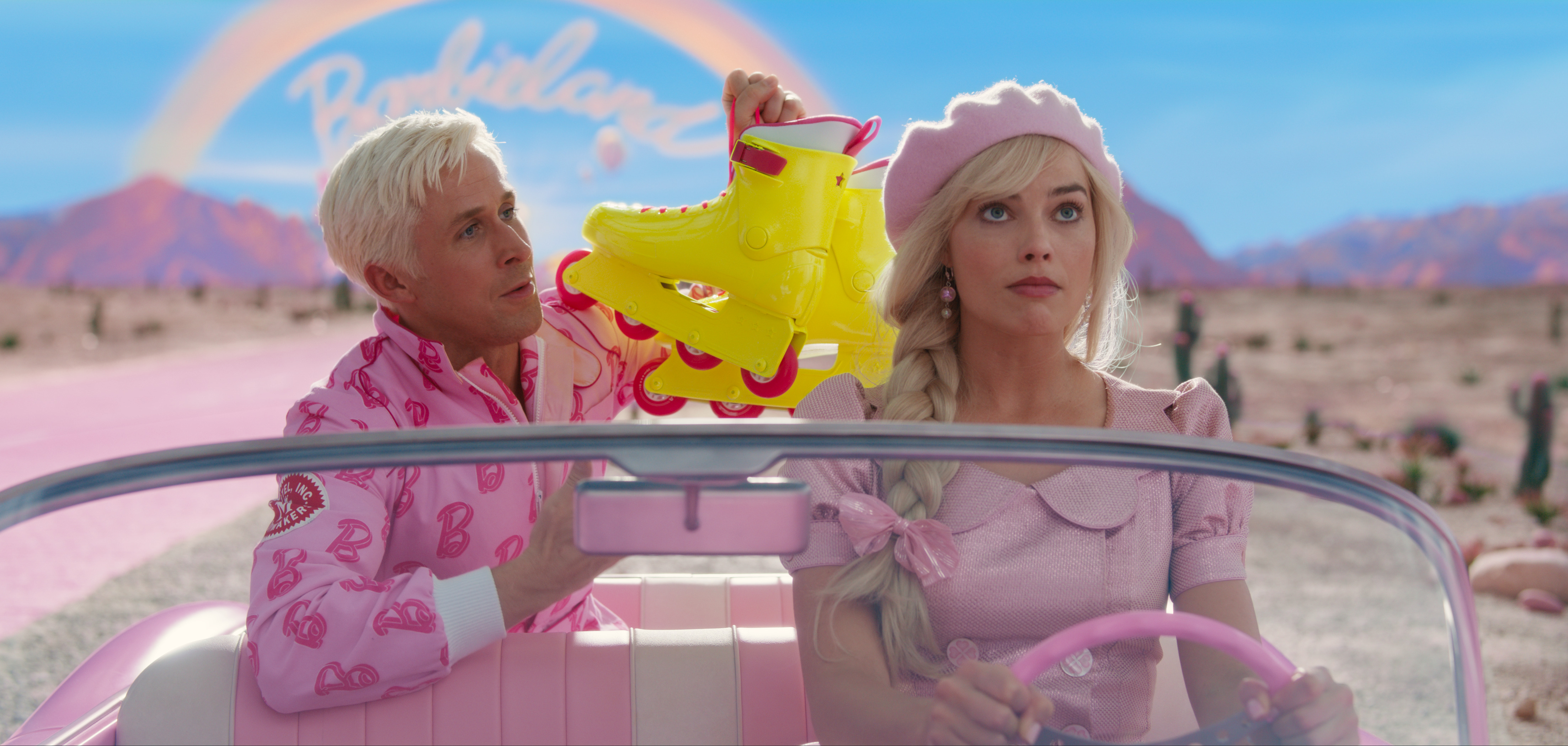 Barbie in an all-pink outfit driving a pink car with Ken in the backseat holding a pair of rollerblades.